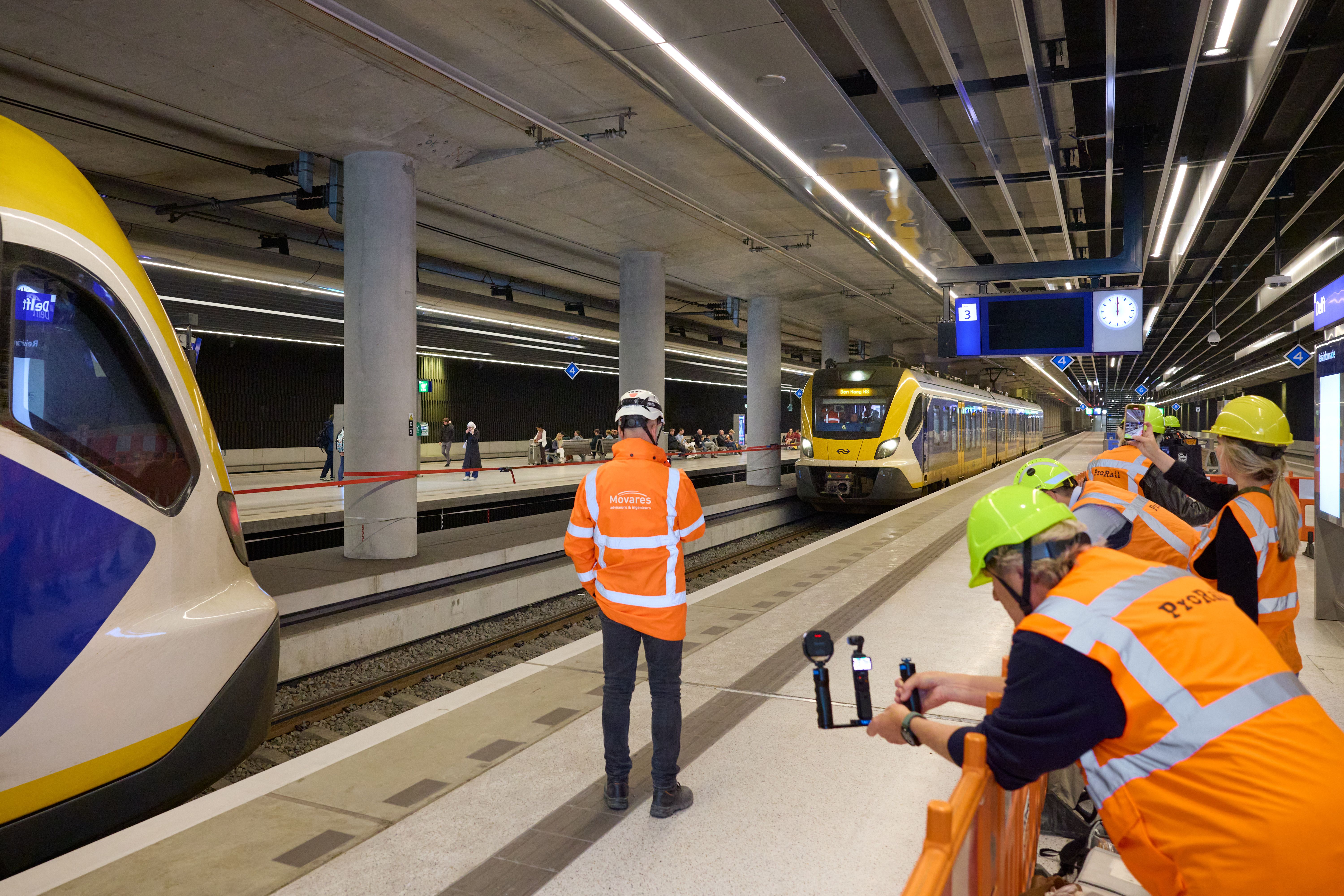 Pers kijkt mee bij het binnenrijden van de trein op het nieuwe spoor 3