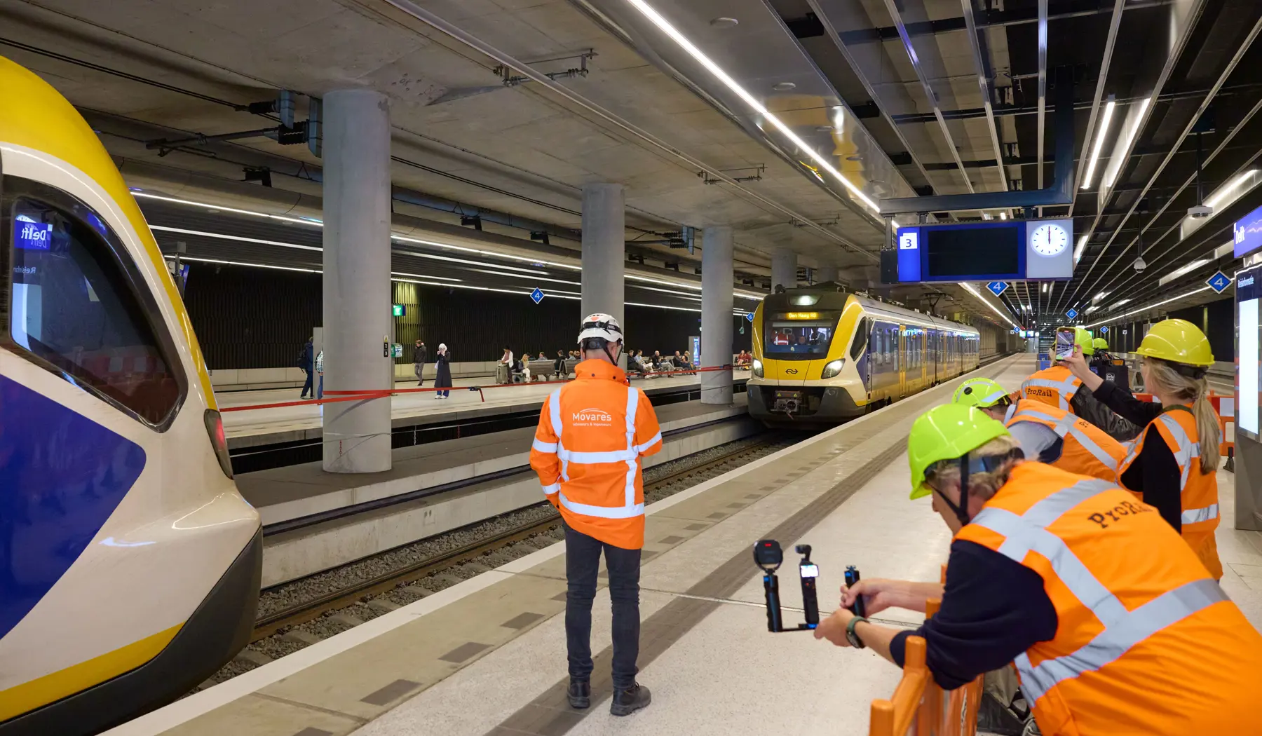 Pers kijkt mee bij het binnenrijden van de trein op het nieuwe spoor 3