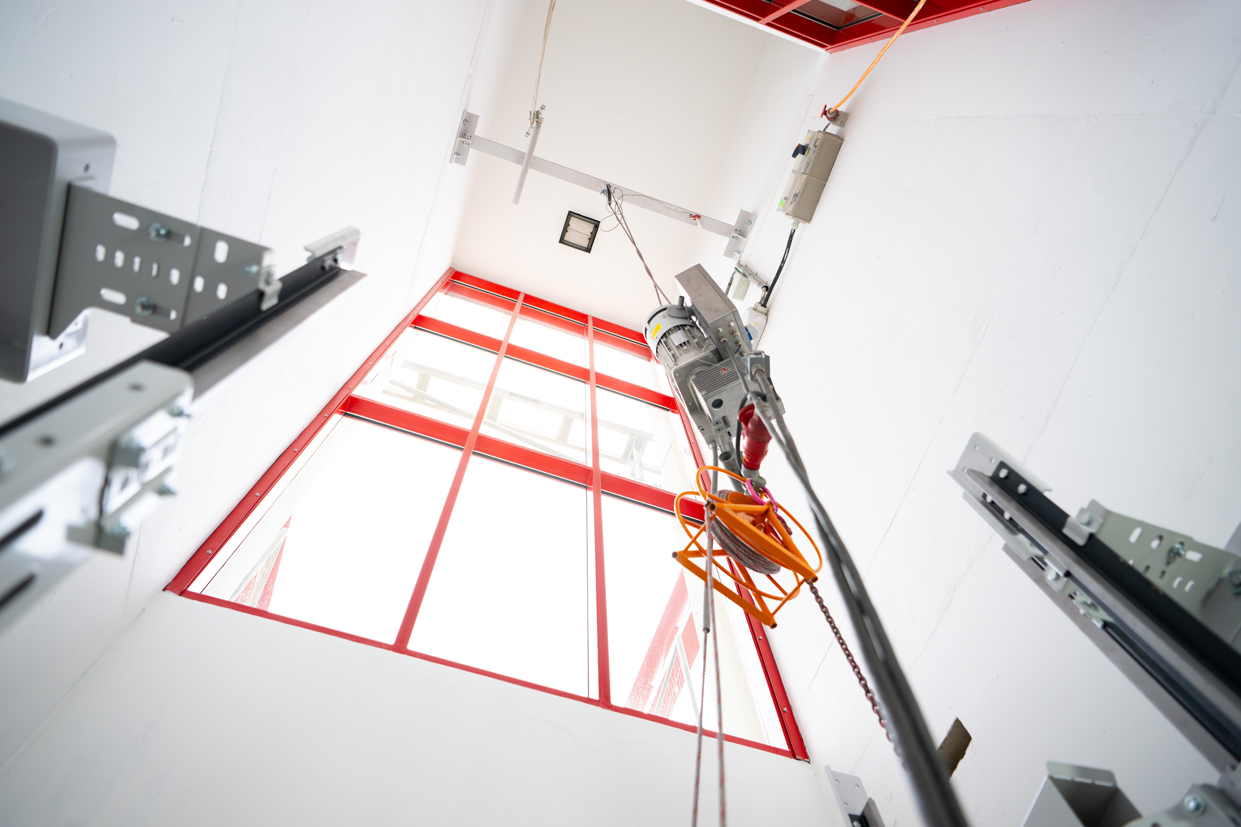 Grote delen van de betonnen liftschachten zijn uitgezaagd om plaats te maken voor glazen puien.