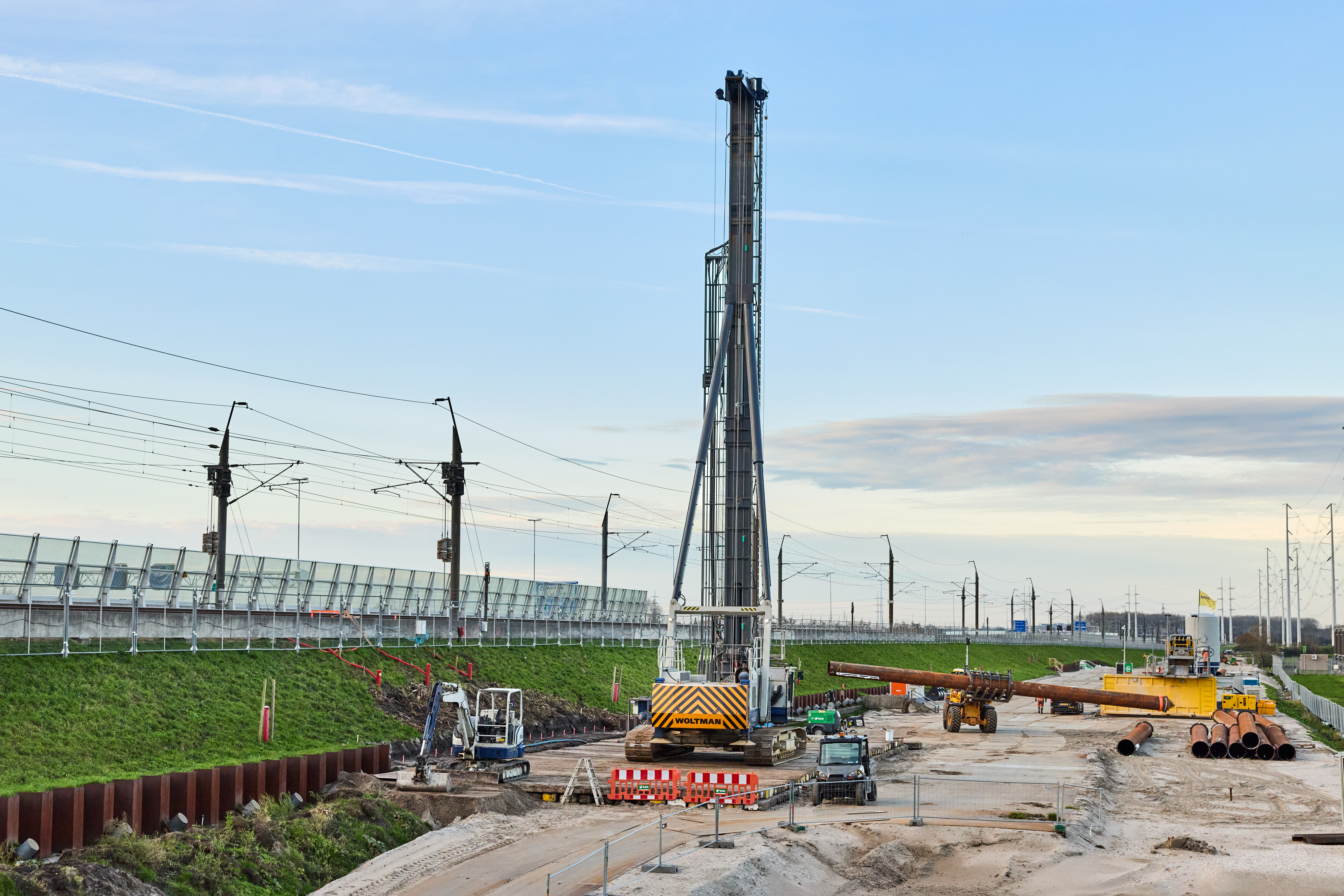 De eerste paal wordt naar de boorstelling (kraan) toegereden. Elke paal is 18 meter lang en 70 centimeter breed. 