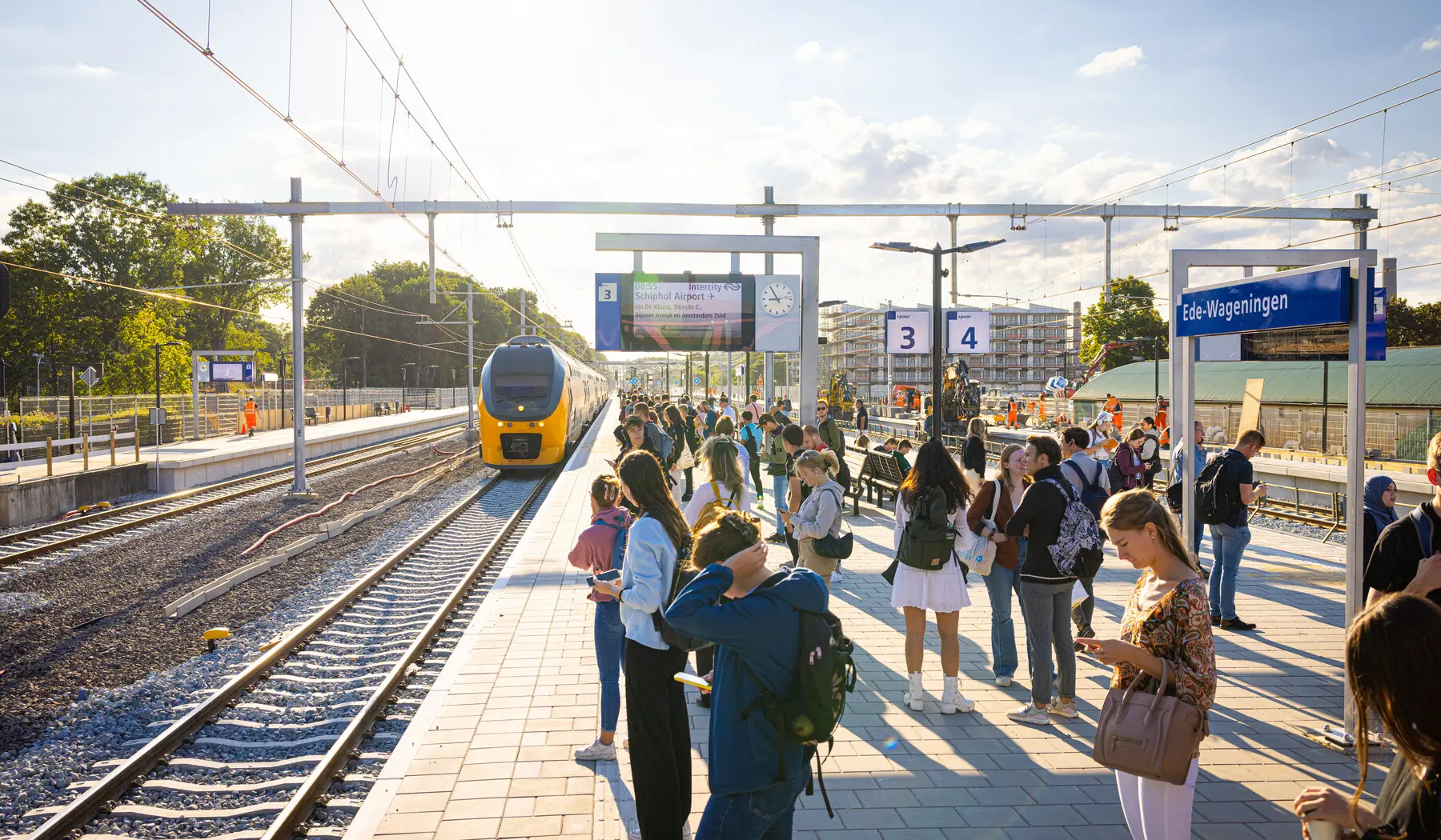 De NS-treinen rijden weer van en naar Ede-Wageningen. Wachtende reizigers op het vernieuwd en verbrede perron.
