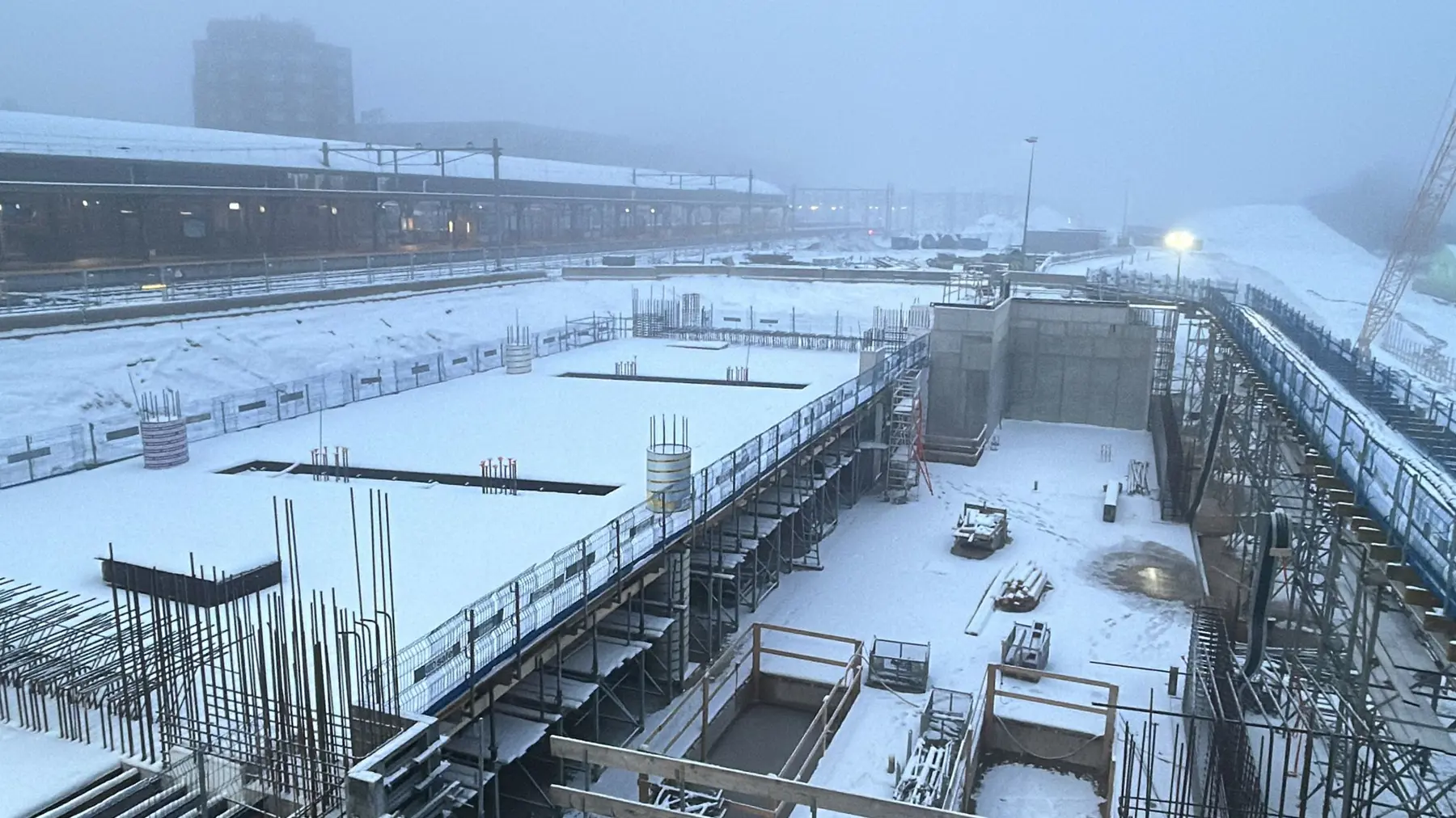 Een besneeuwde bouwplaats met links het tunneldeel in aanbouw. 