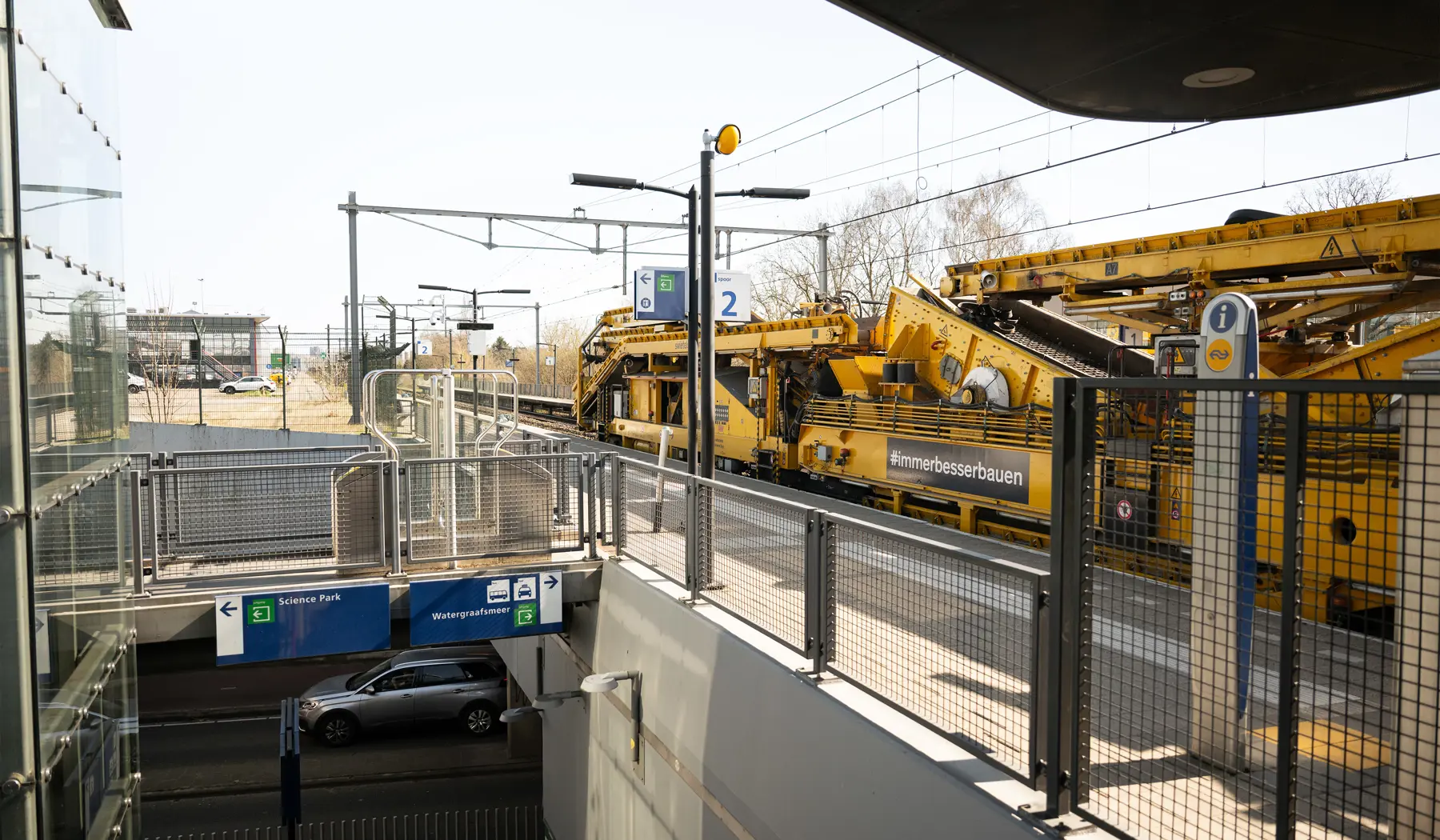 De rijdende fabriek passeert stapvoets een verlaten station Amsterdam Science Park