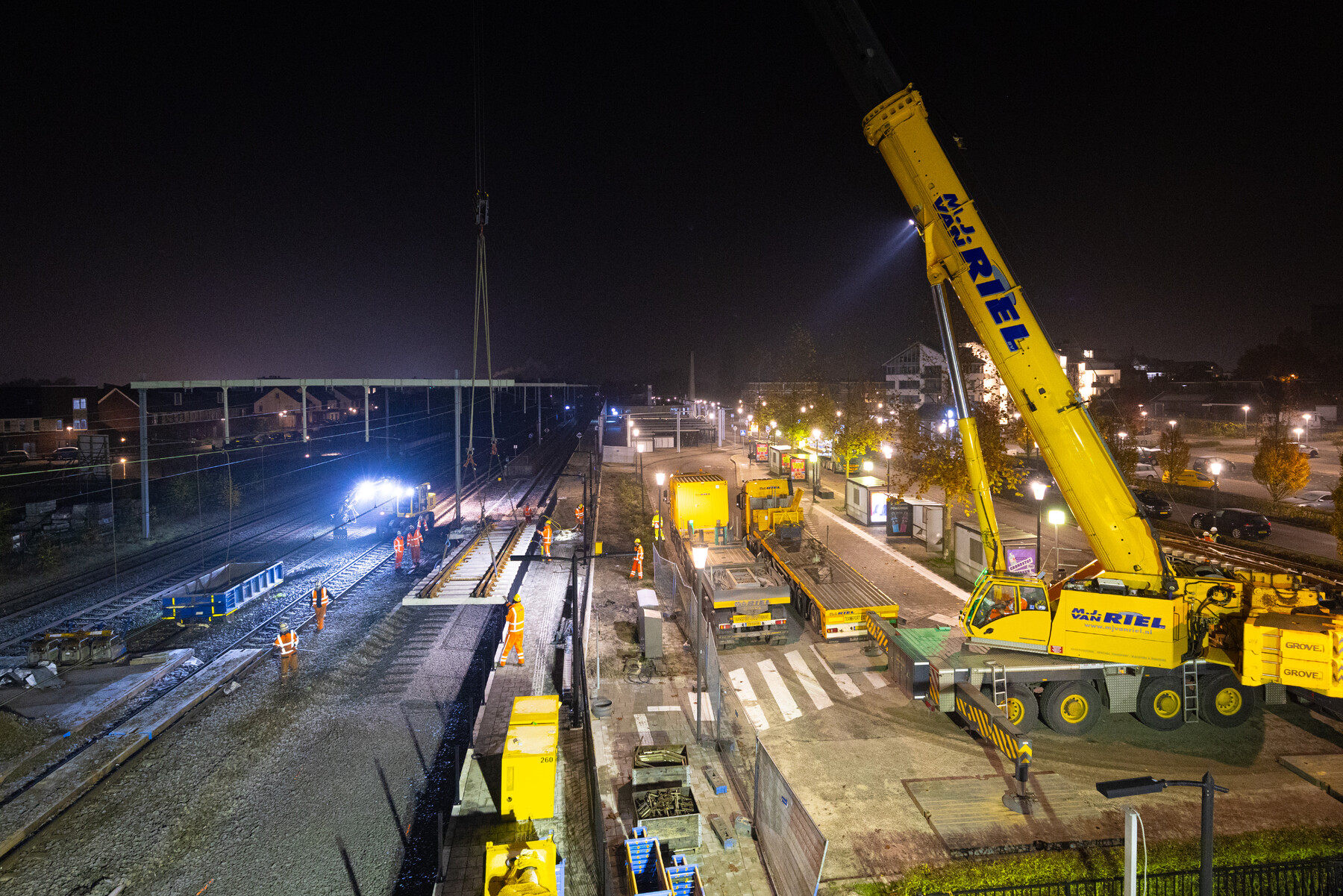 Met een telekraan wordt het nieuwe wissel in delen op zijn plek gelegd. 