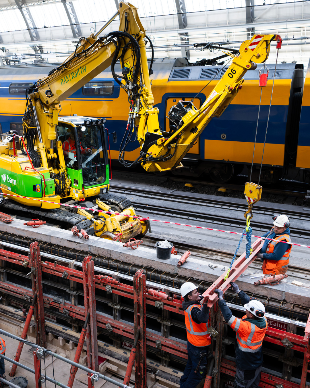 De kraan hijst een onderdeel van de bekisting in ten behoeve van het maken van een betonnen balk langs het perron