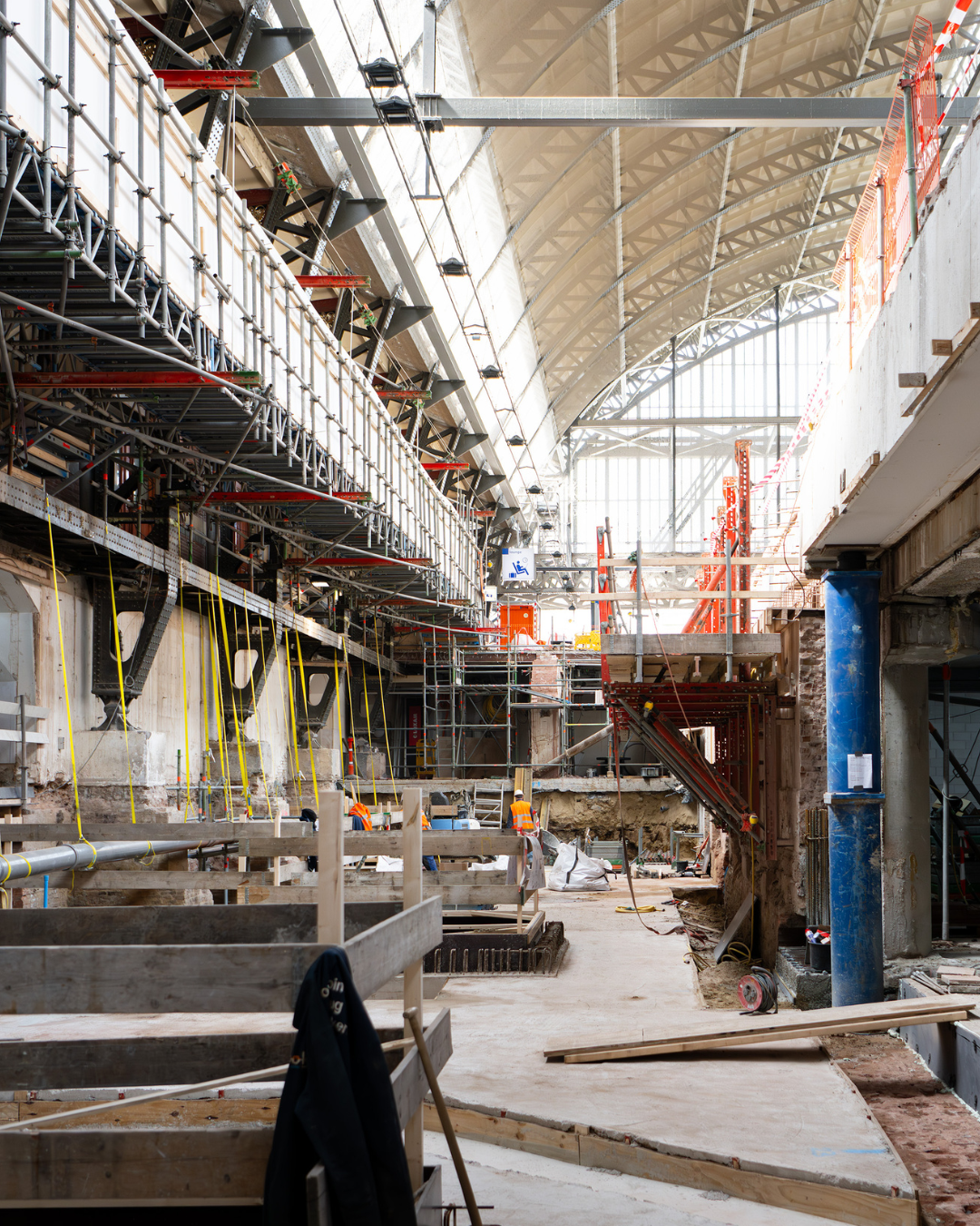 In de bouwput zien we oa ook al de vloer, de aanzet voor de lift- en rotrapput, ondersteuning voor de monumentale perronrand, de hulpburg en een steiger voor het aanbrengen van de betonnen balk 
