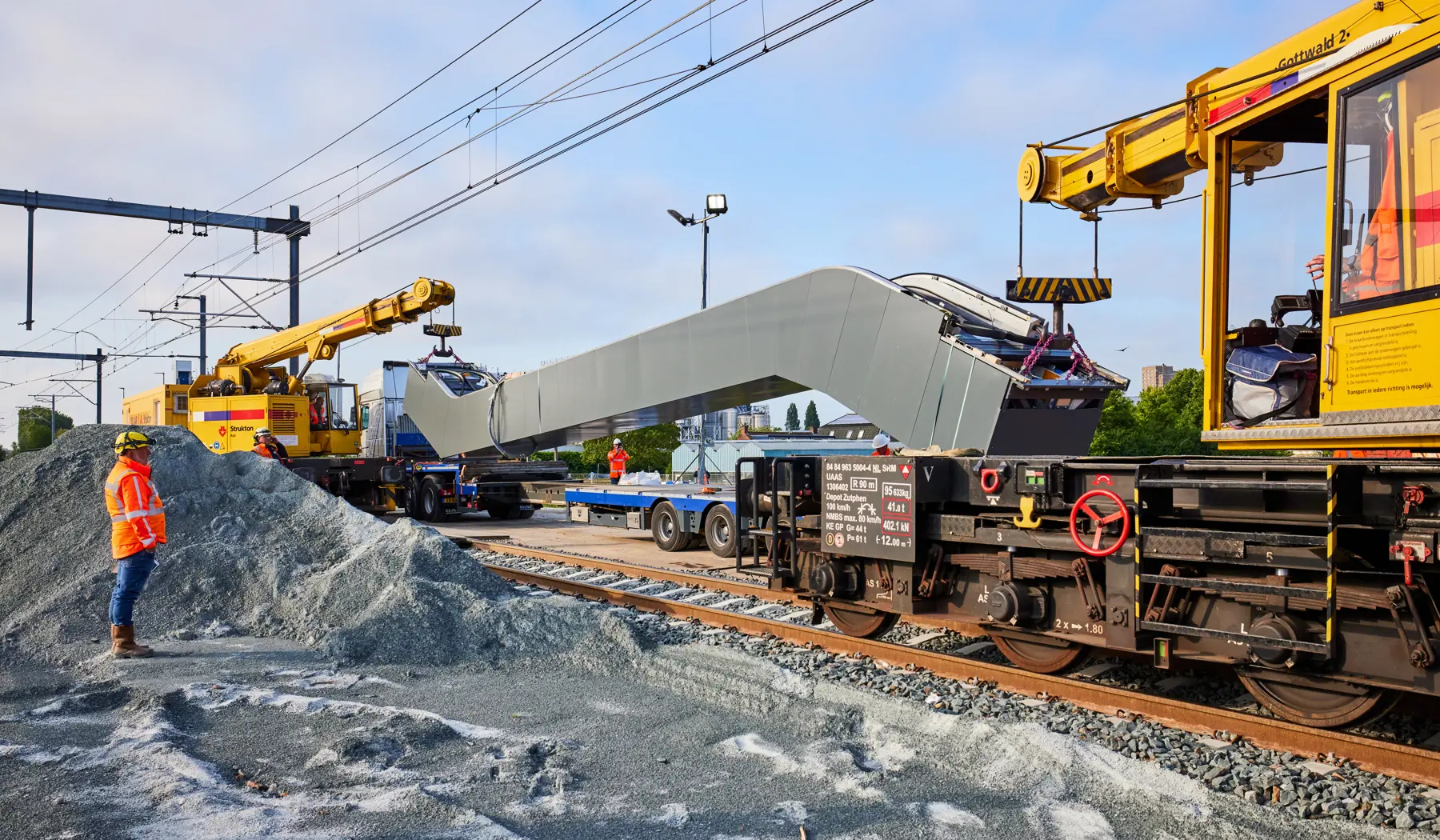 De roltrap wordt vanaf de vrachtwagen gehesen tussen de twee Gottwaldkranen.