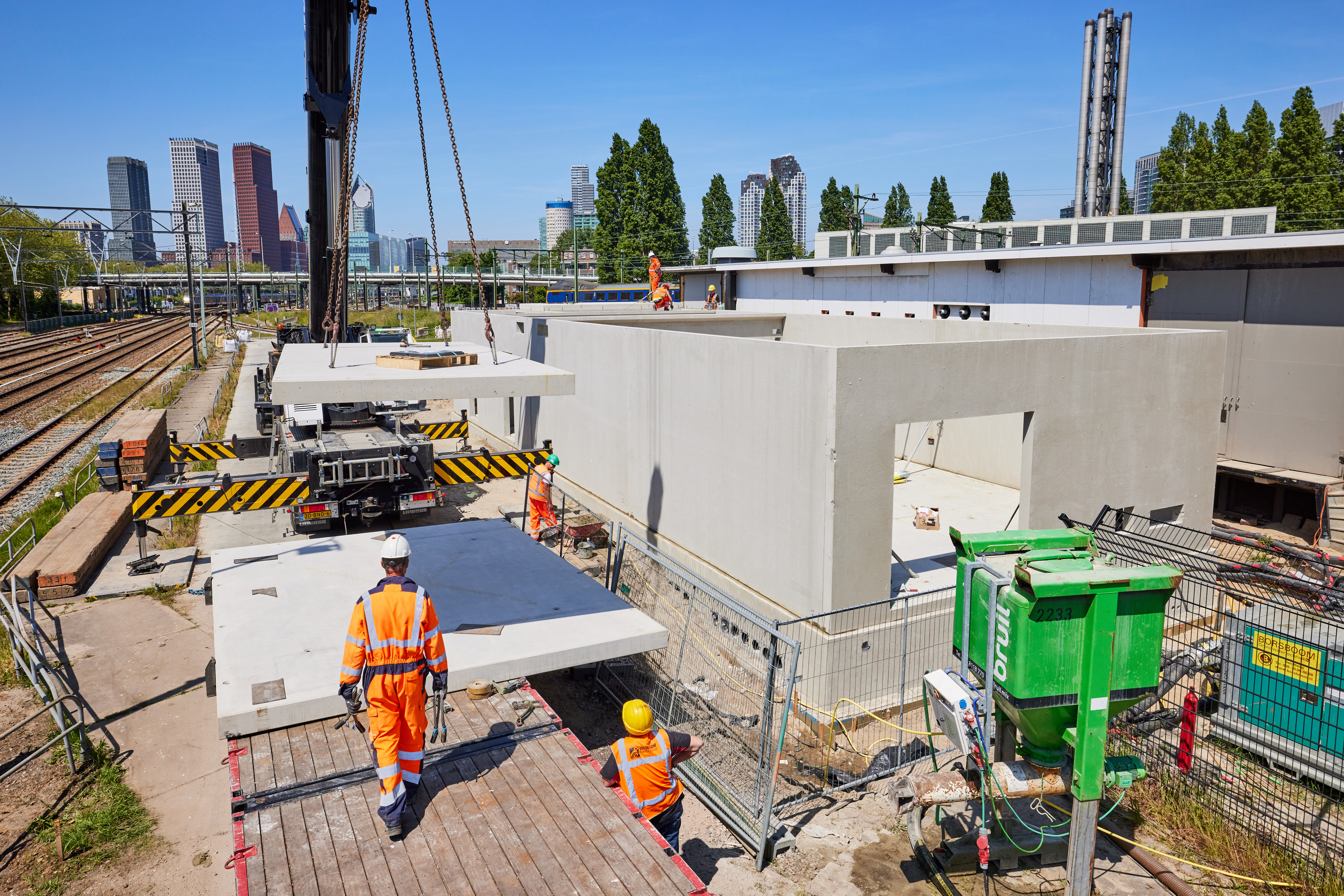 Het hijsen van dakplaten voor het nieuwe relaisgebouw.