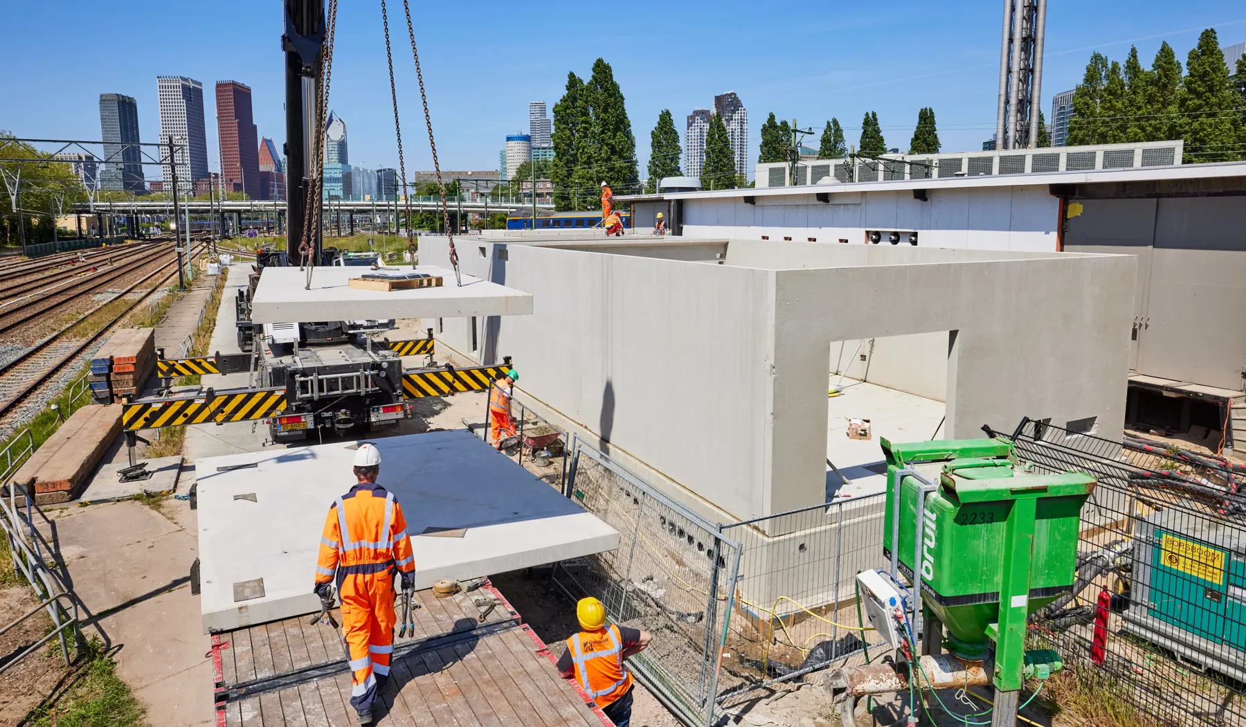 Het hijsen van dakplaten voor het nieuwe relaisgebouw.