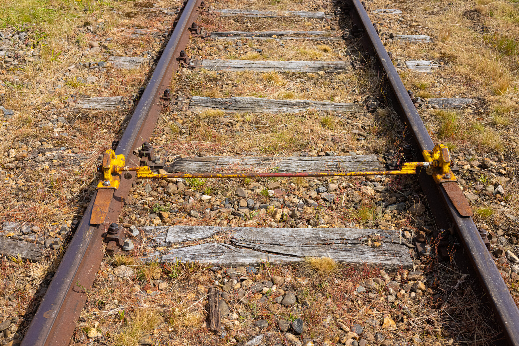 De remslof: een speciale stalen constructie die op het spoor wordt gelegd om wagons af te remmen en op hun plaats te houden