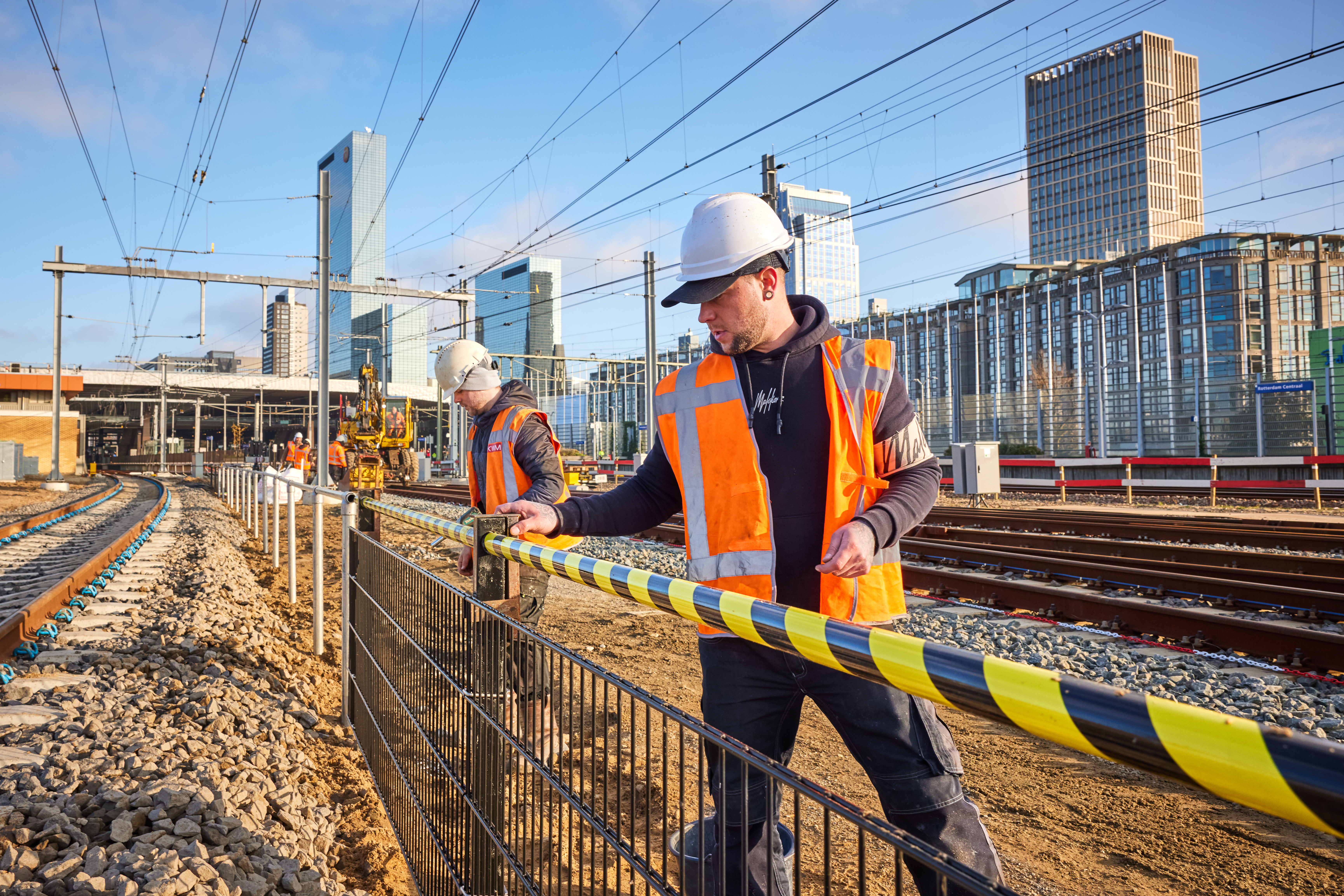 Deze mannen plaatsen een hekwerk: de scheiding tussen machinistenpad en sporen. Hierdoor kunnen machinisten veilig naar de treinen lopen