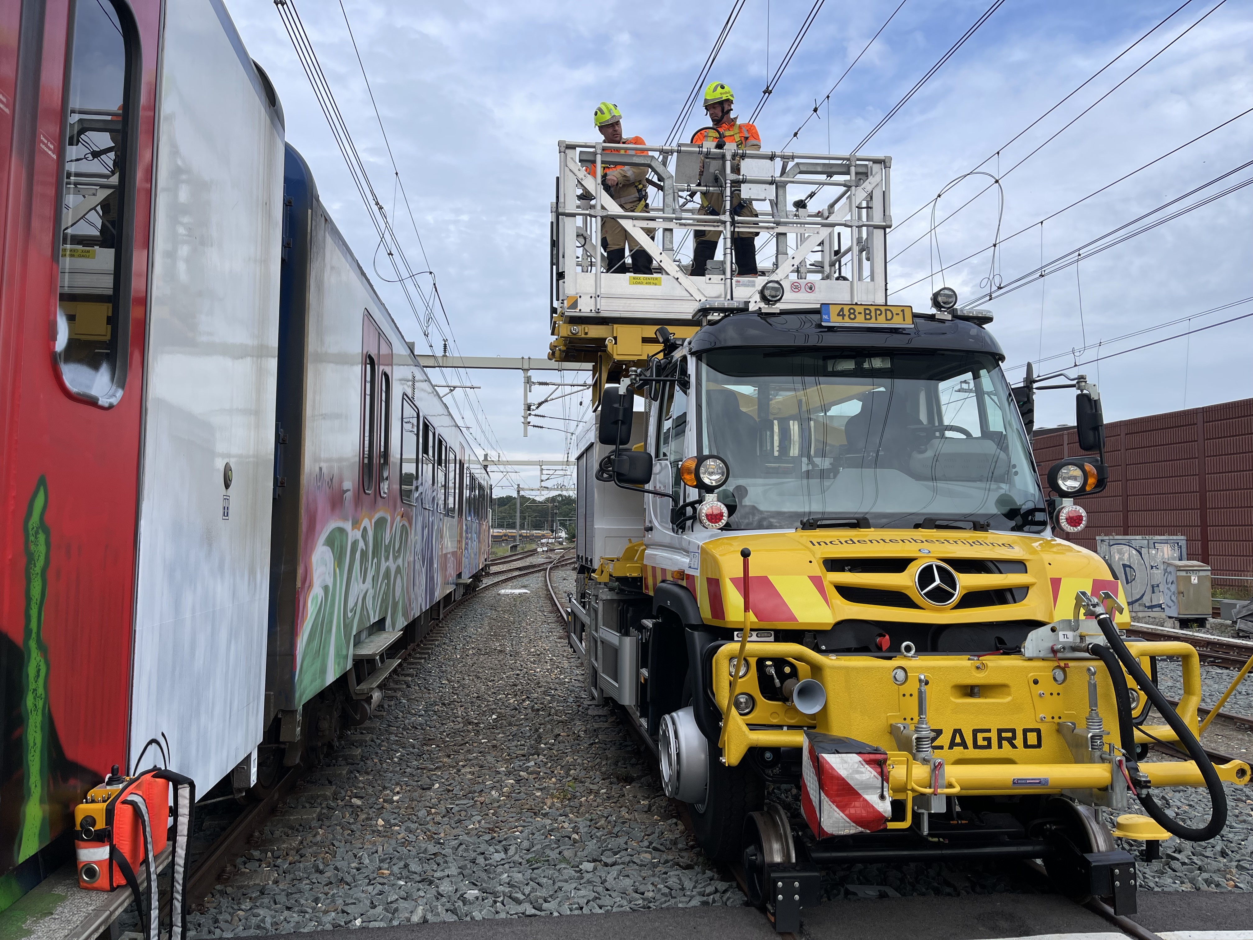 Twee medewerkers aan het werk vanaf de hoogwerker van de Unimog