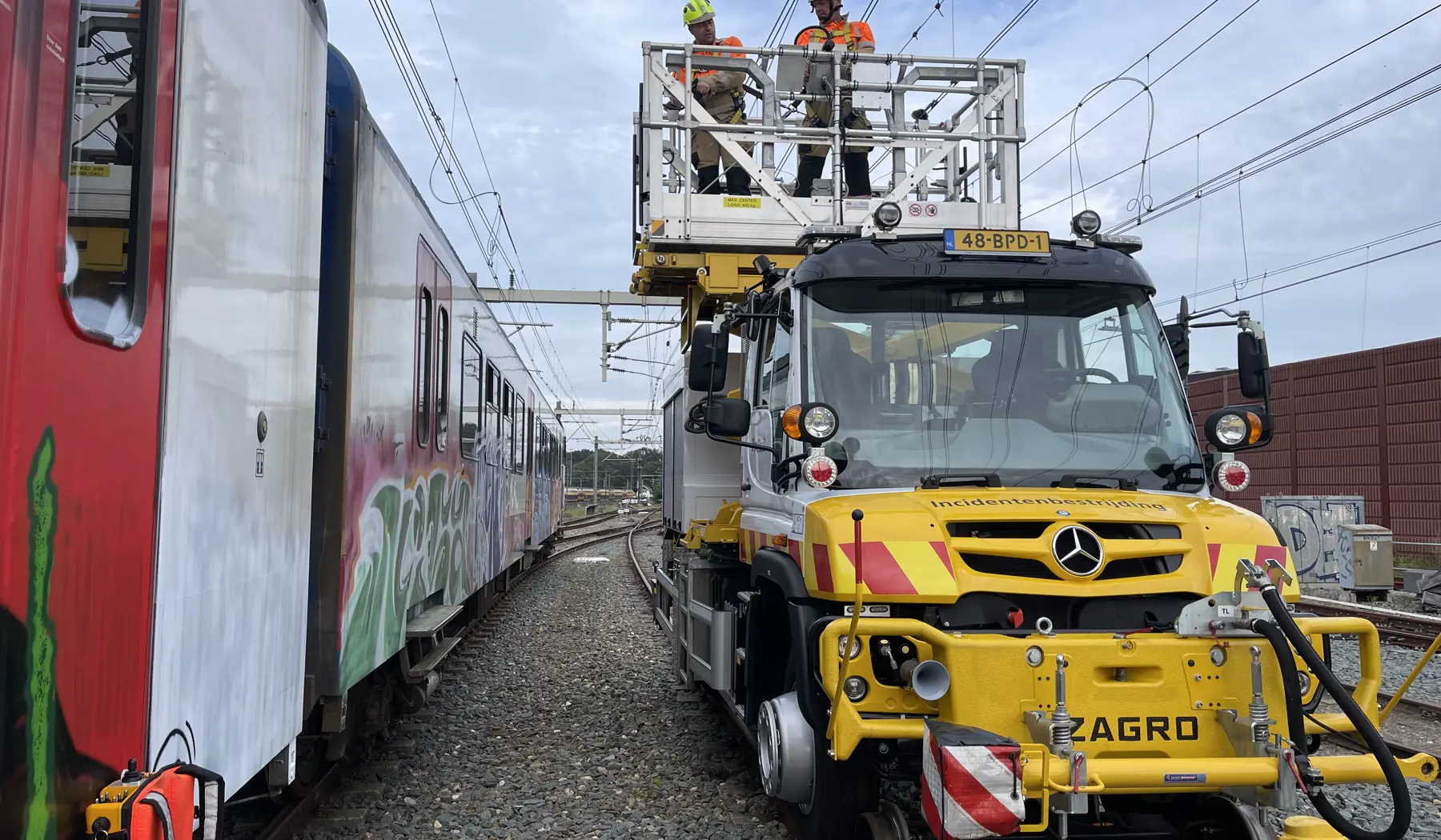 Twee medewerkers aan het werk vanaf de hoogwerker van de Unimog