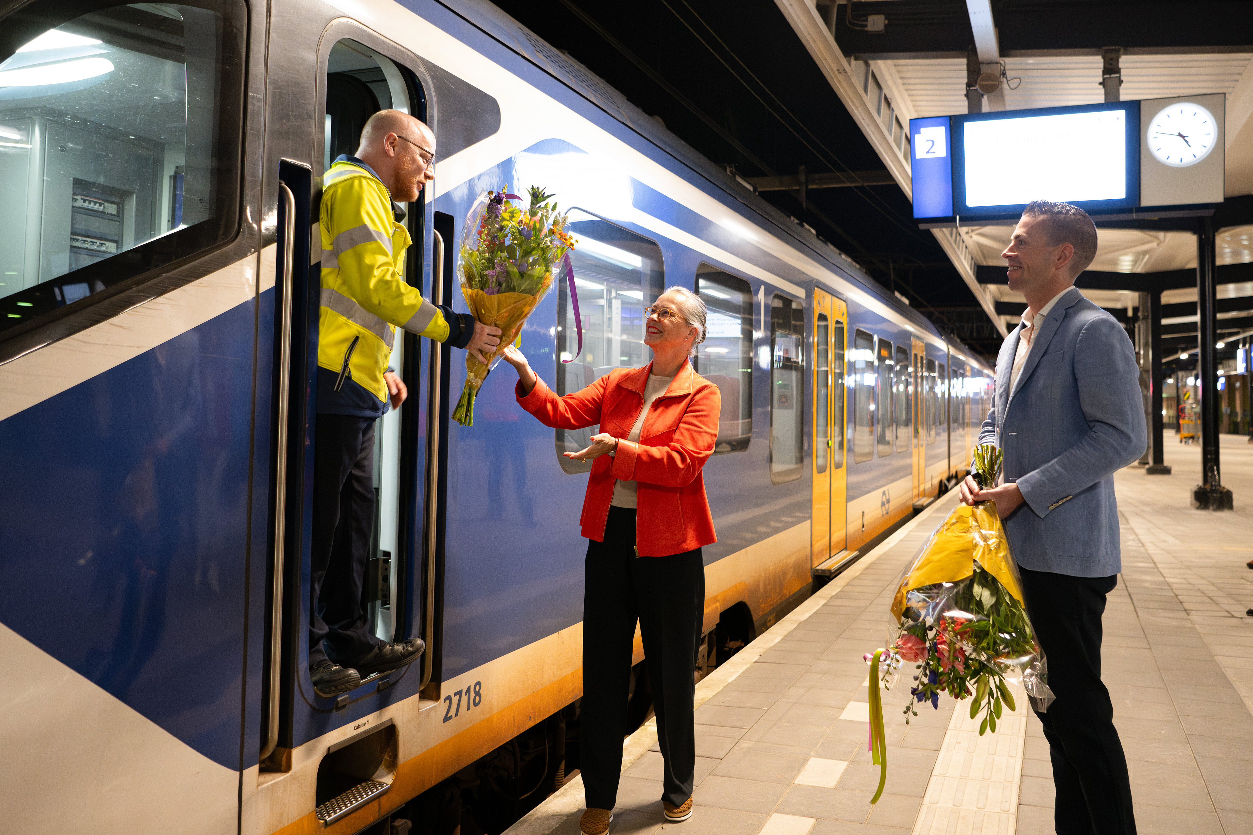 Irma Winkenius, regiodirecteur NS, overhandigt bloemen aan de eerste NS-machinist die weer vanaf Amersfoort Centraal rijdt