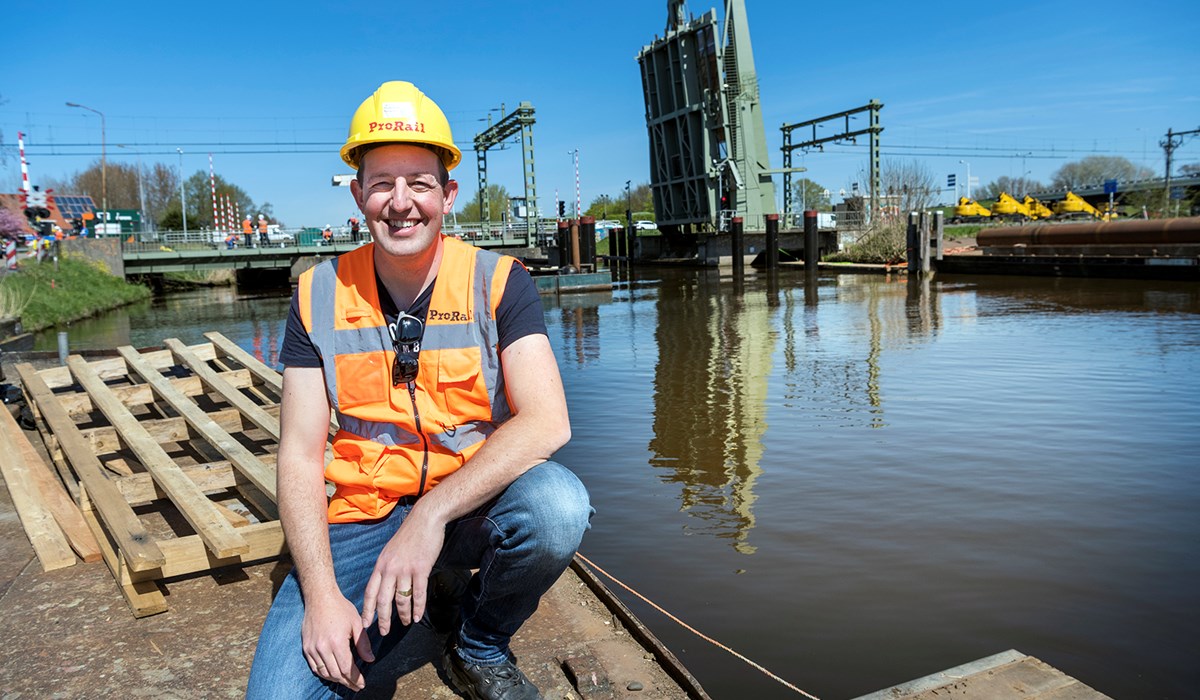 Bastiaan Logtmeijer, bouwmanager, met op de achtergrond de geopende spoorbrug