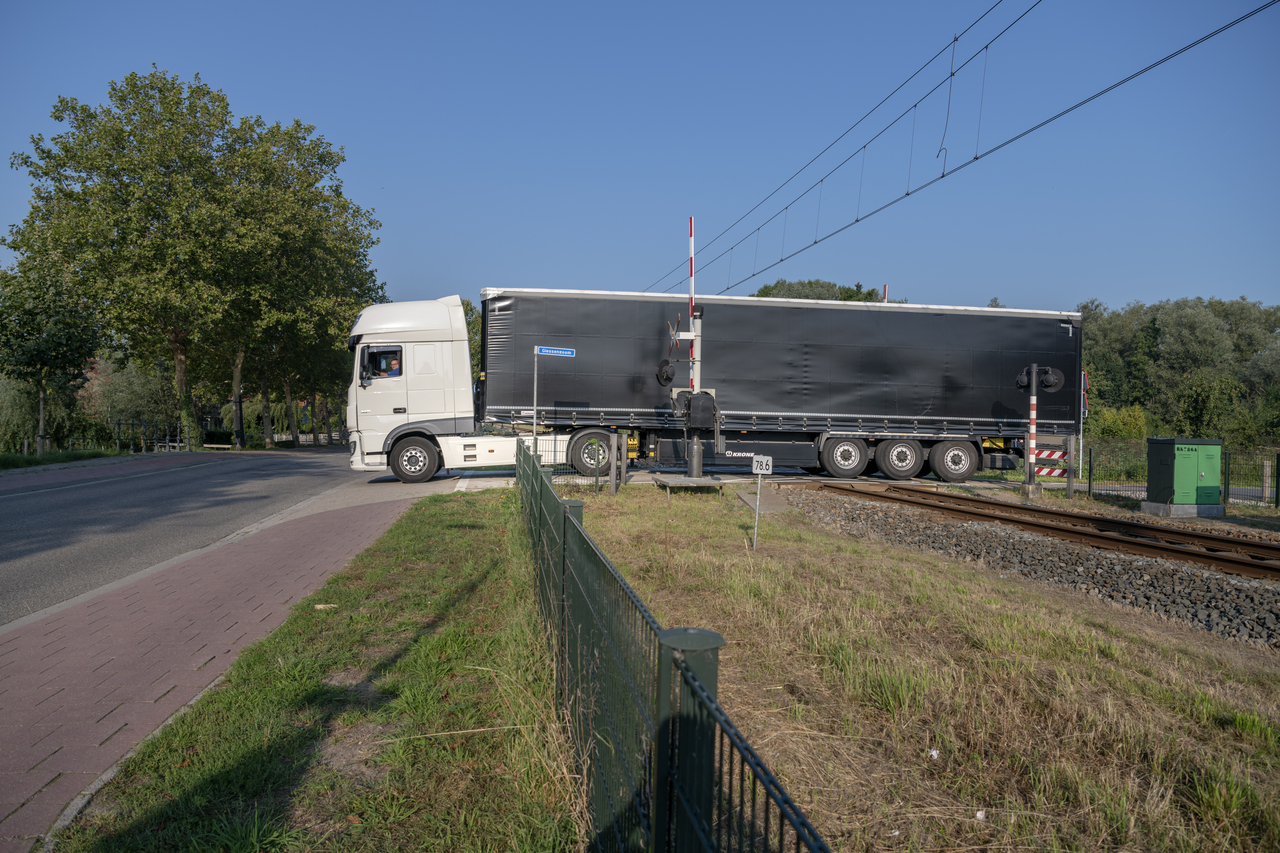 De oude situatie: vrachtwagens moeten stilstaan op de overweg om op de Parallelweg te komen