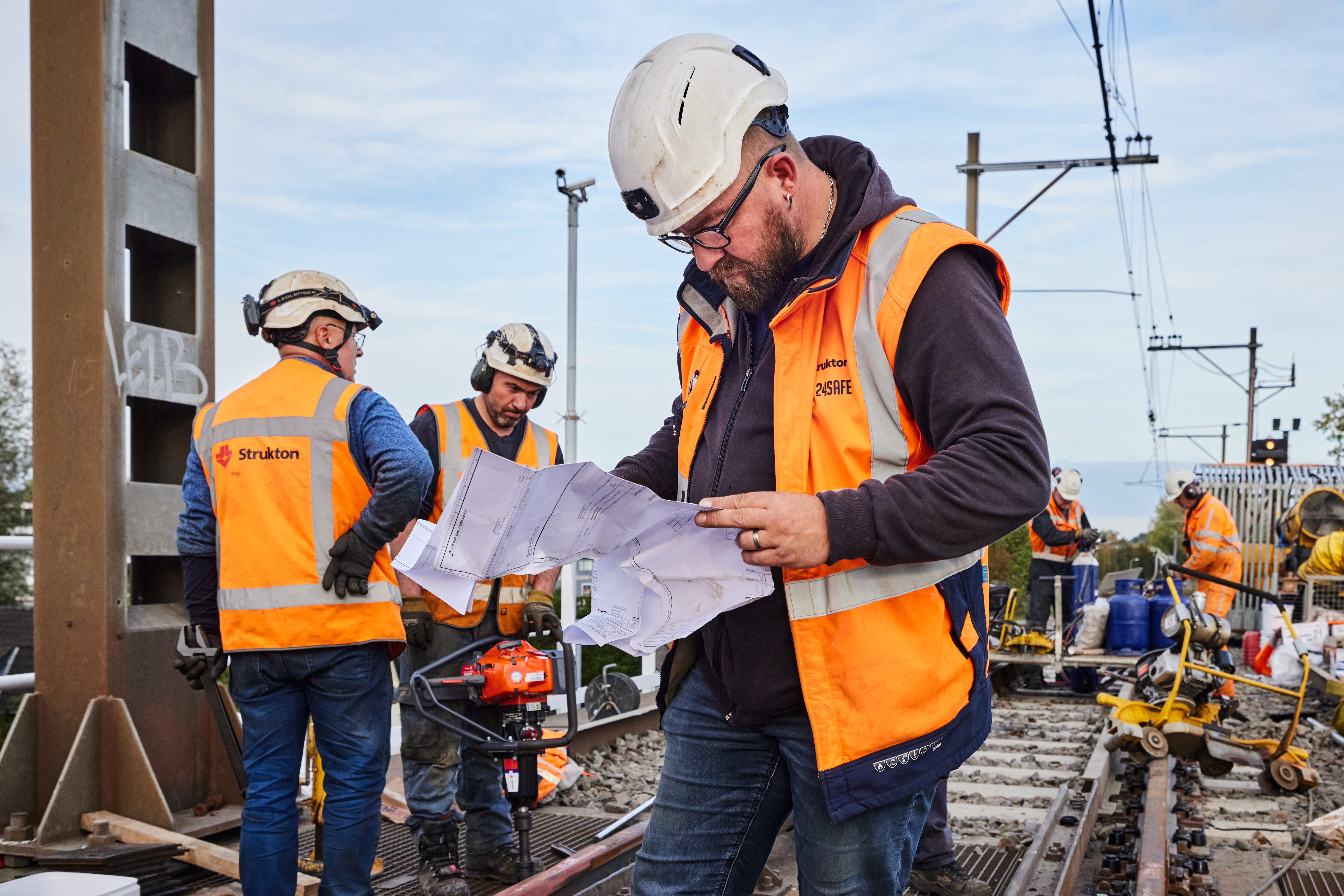 De uitvoerder controleert hoe het spoor weer moet worden opgebouwd
