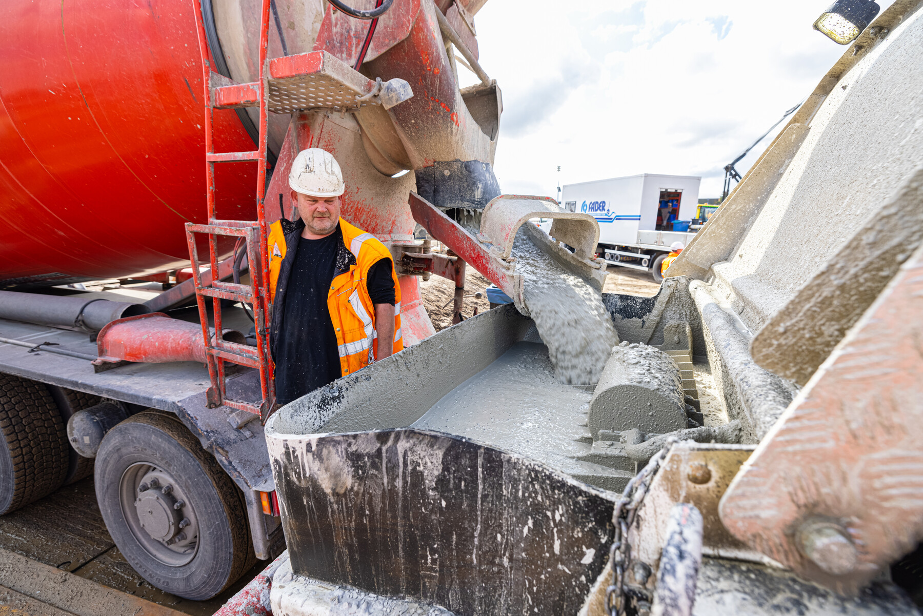 Het overstorten van beton van vrachtwagen naar machine