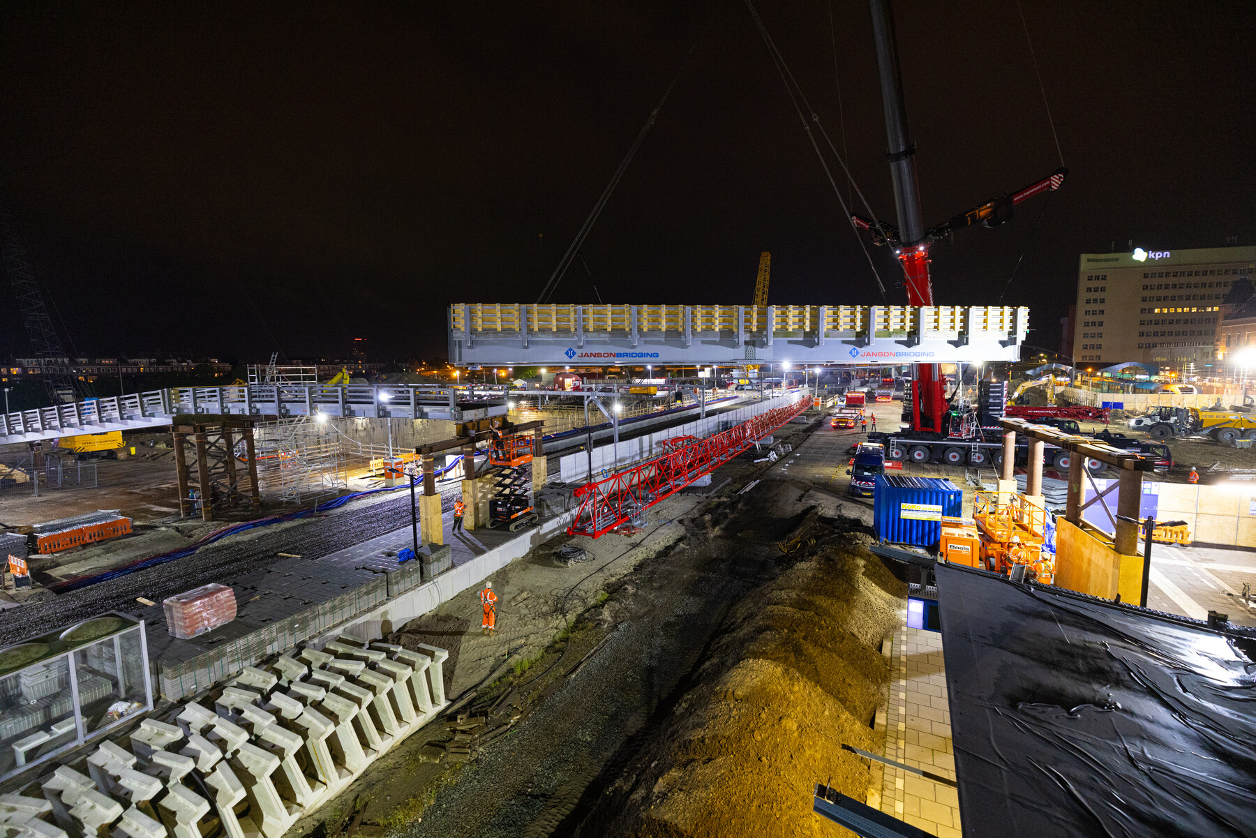 Het hijsen van de brugdekken voor de hulpbrug over het spoor