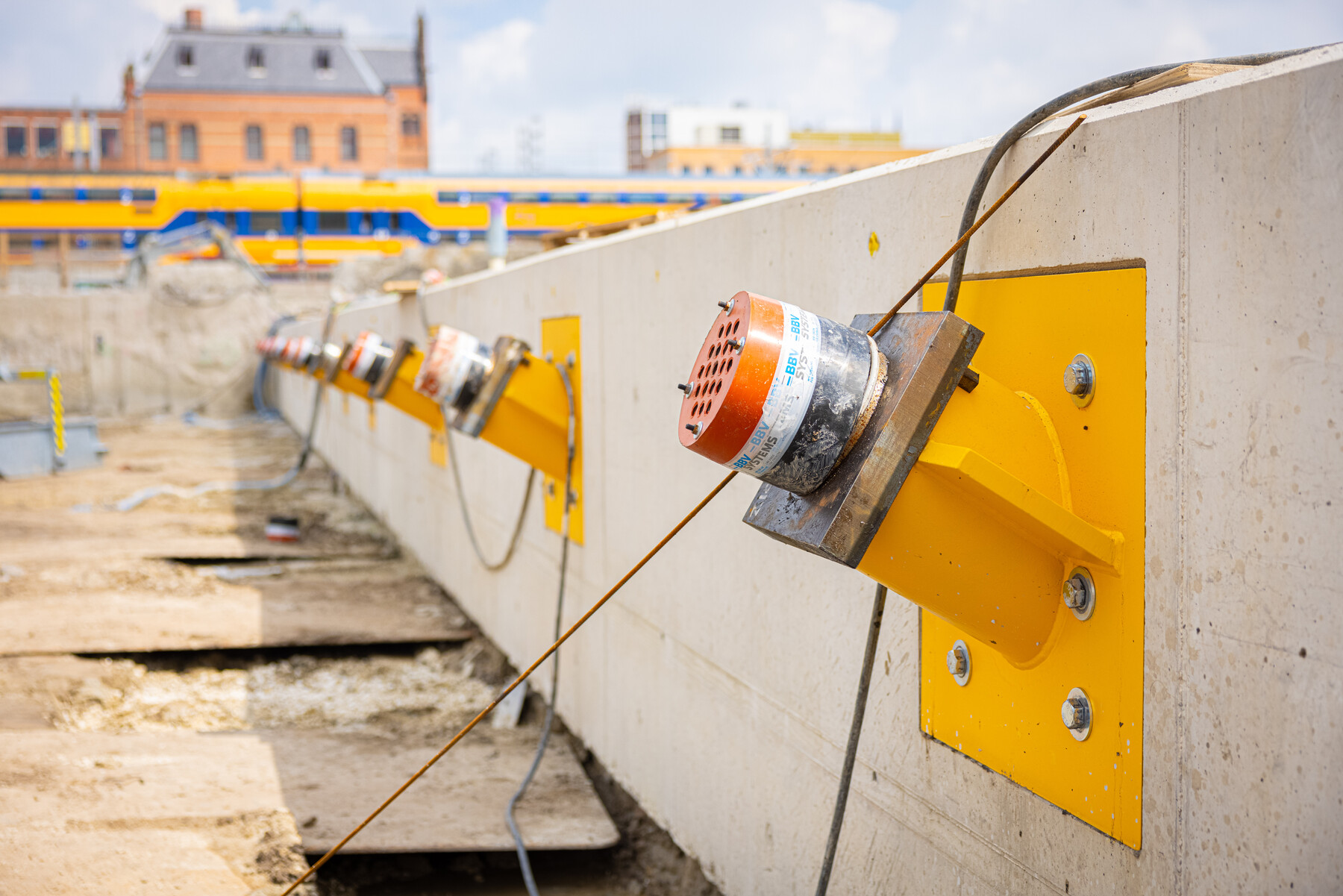 De deksloof aan de oostkant is klaar. De verankering (groutankers) door de deksloof en diepwand is duidelijk herkenbaar aan de gele ankerstoelen. 