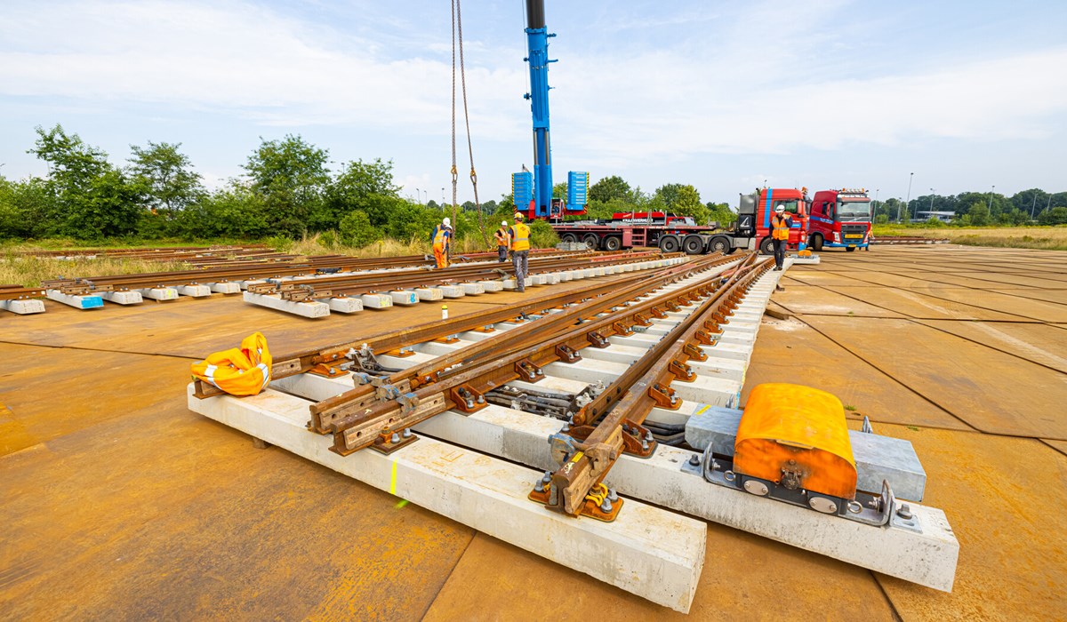 Vanaf de Panovenlaan takelt Swietelsky nieuwe spoor- en wisseldelen met een 450 tons zware telekraan op treinen die de nieuwe spooronderdelen naar de spoorlocatie transporteren