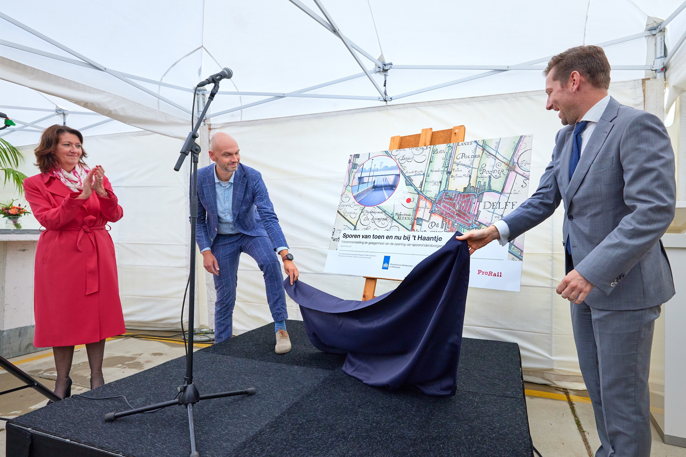 Helga Cuijpers (ProRail), Paul Bolt (ministerie Infrastructuur & Waterstaat) en Jeffrey Keus (wethouder RijswijkBuiten) onthullen de fototentoonstelling 
