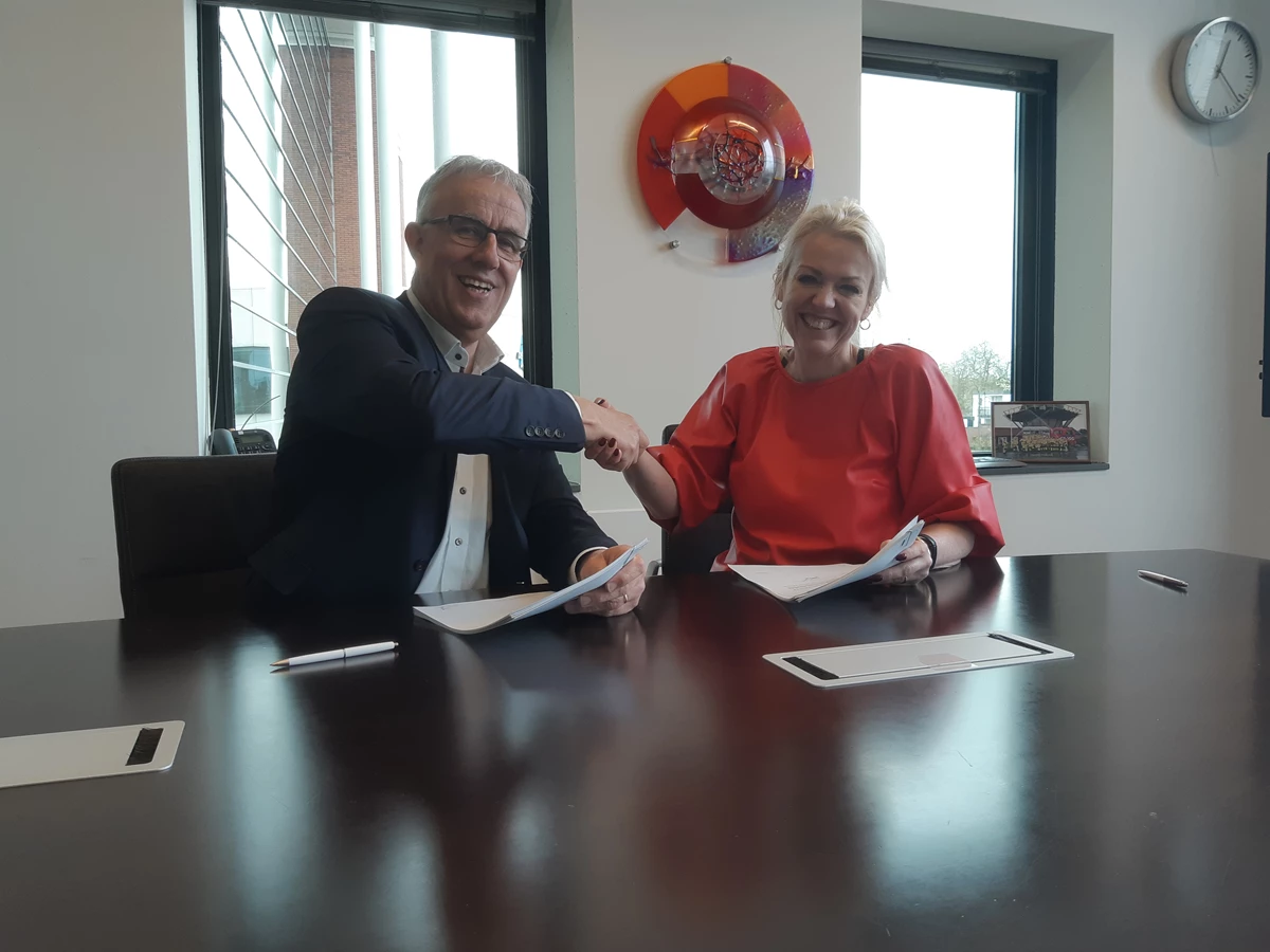 Harry Scholten (wethouder van de gemeente Hof van Twente) en Dorothé Wennekendonk (regiodirecteur bij ProRail) ondertekenen de overeenkomst