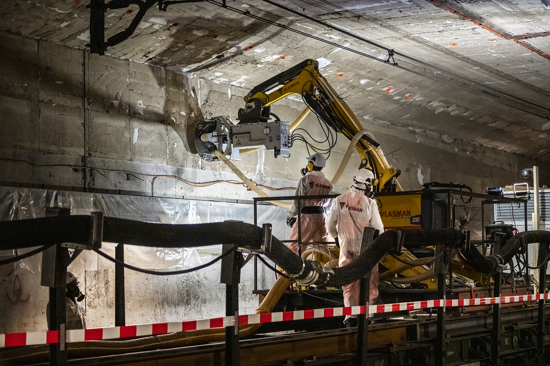 De asbesthoudende lijm wordt uit de spoortunnel verwijderd.