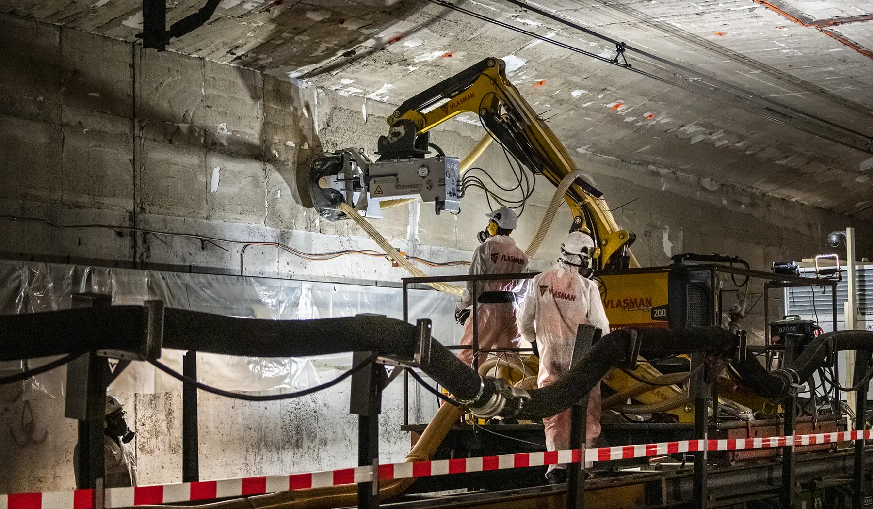 De asbesthoudende lijm wordt uit de spoortunnel verwijderd.
