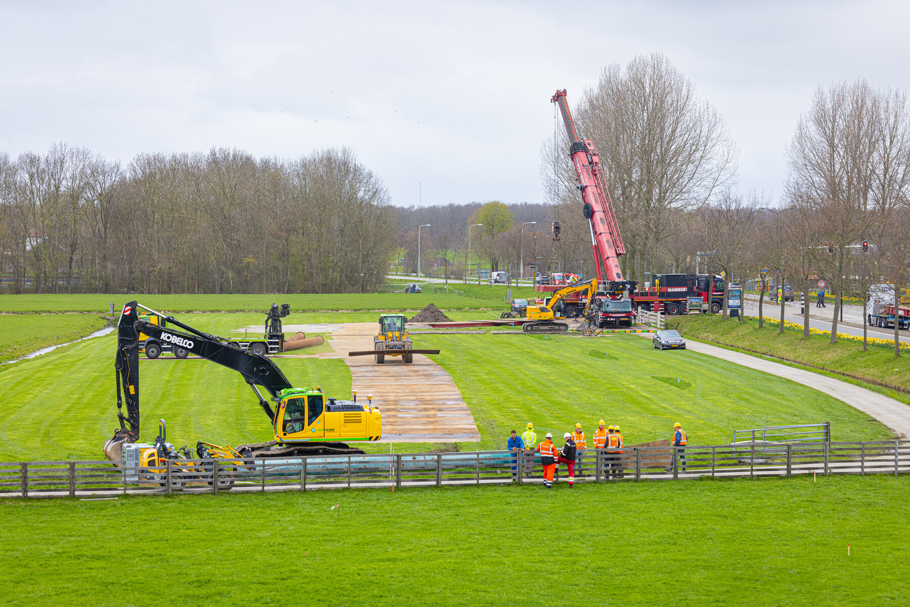 De tijdelijk weg over het drassige weiland wordt aangelegd