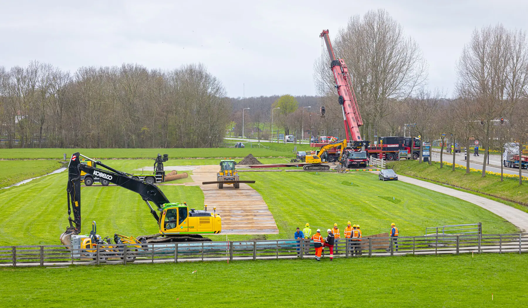 De tijdelijk weg over het drassige weiland wordt aangelegd