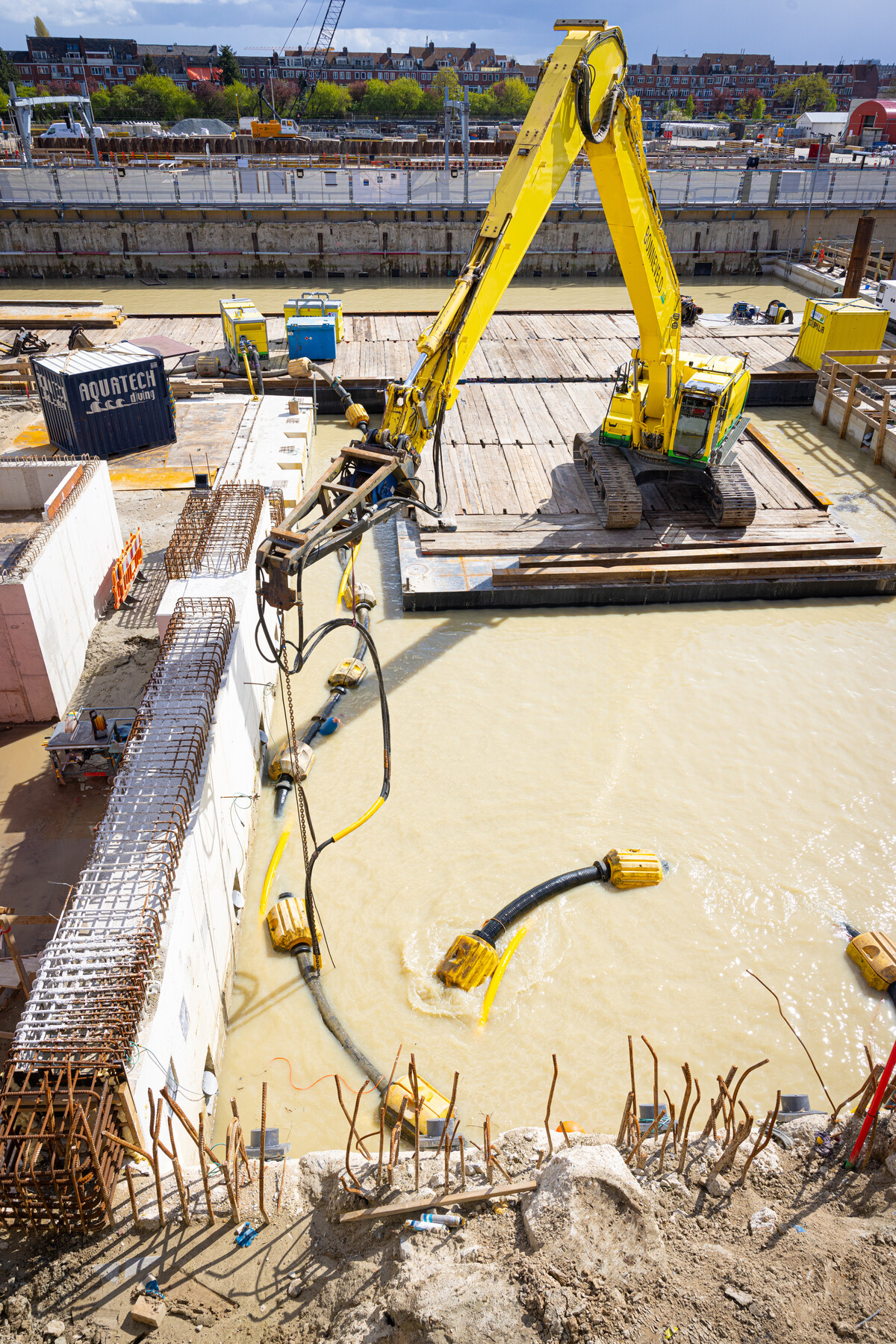 De machine zuigt zand en slib van de bodem van de bouwkuip