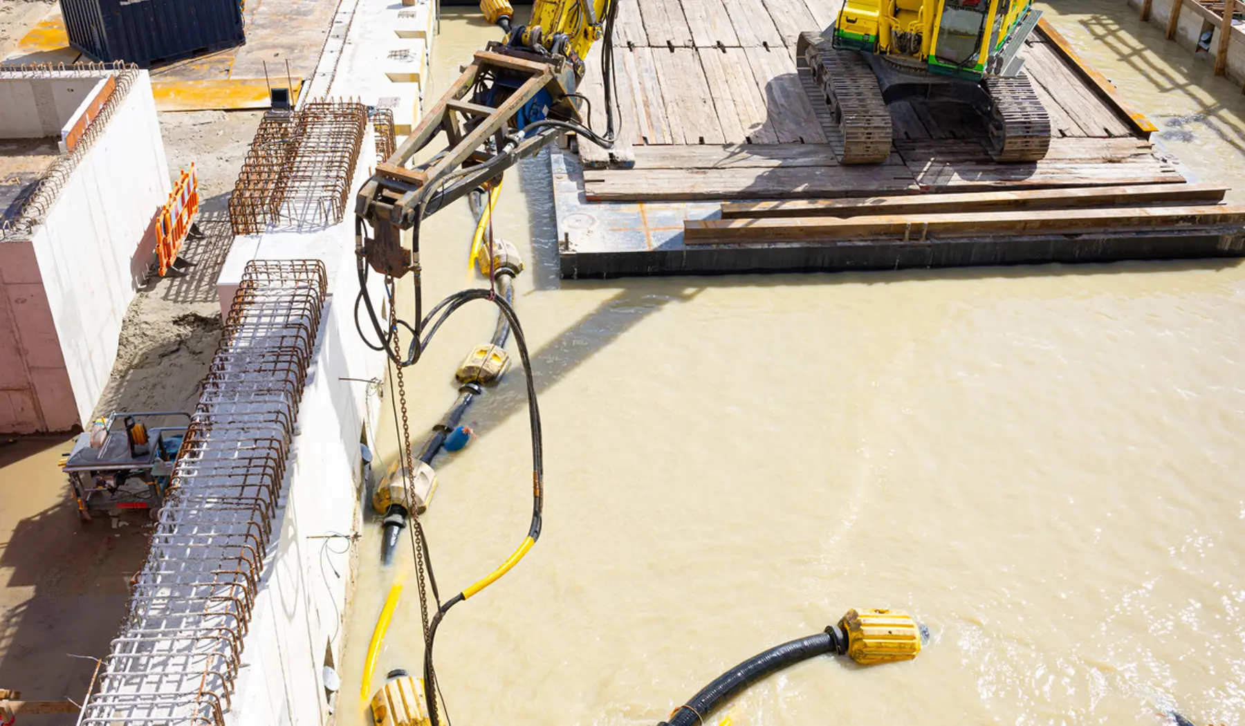 De machine zuigt zand en slib van de bodem van de bouwkuip