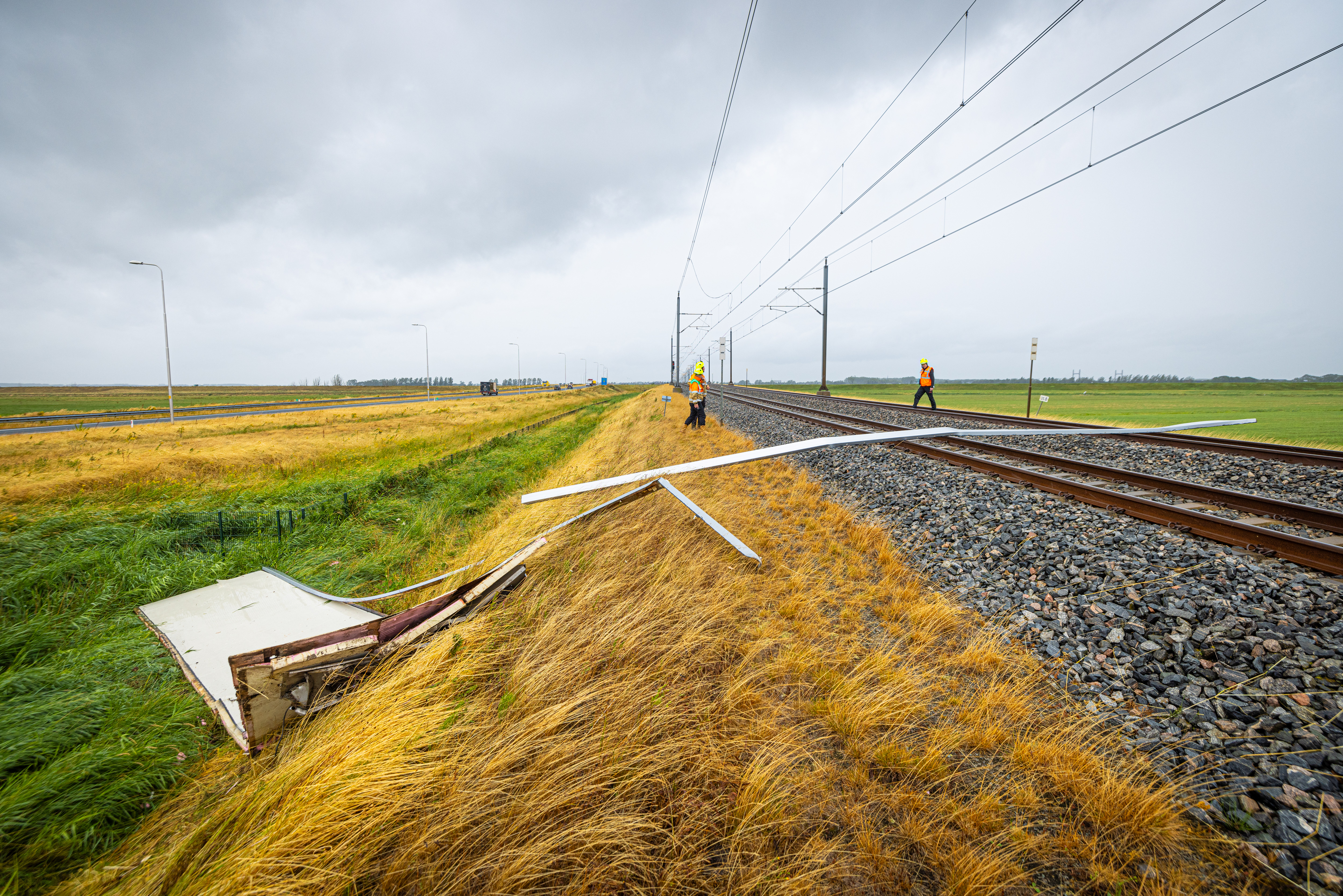 Een stuk van het dak van een vrachtwagen is op het spoor gewaaid