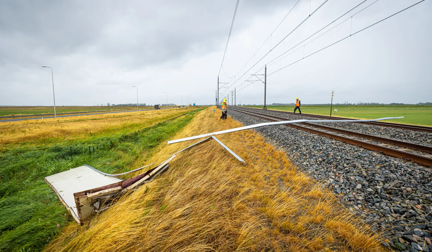 Een stuk van het dak van een vrachtwagen is op het spoor gewaaid