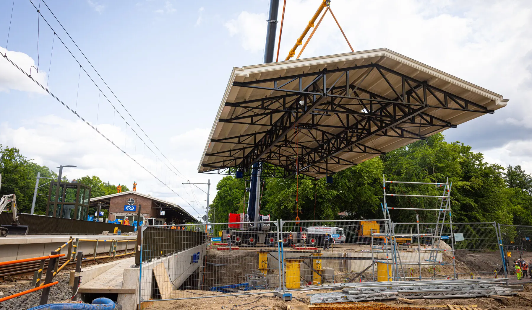 De perronkap is voorgebouwd, vlak naast het station, en werd vanaf daar op z'n plek gehesen