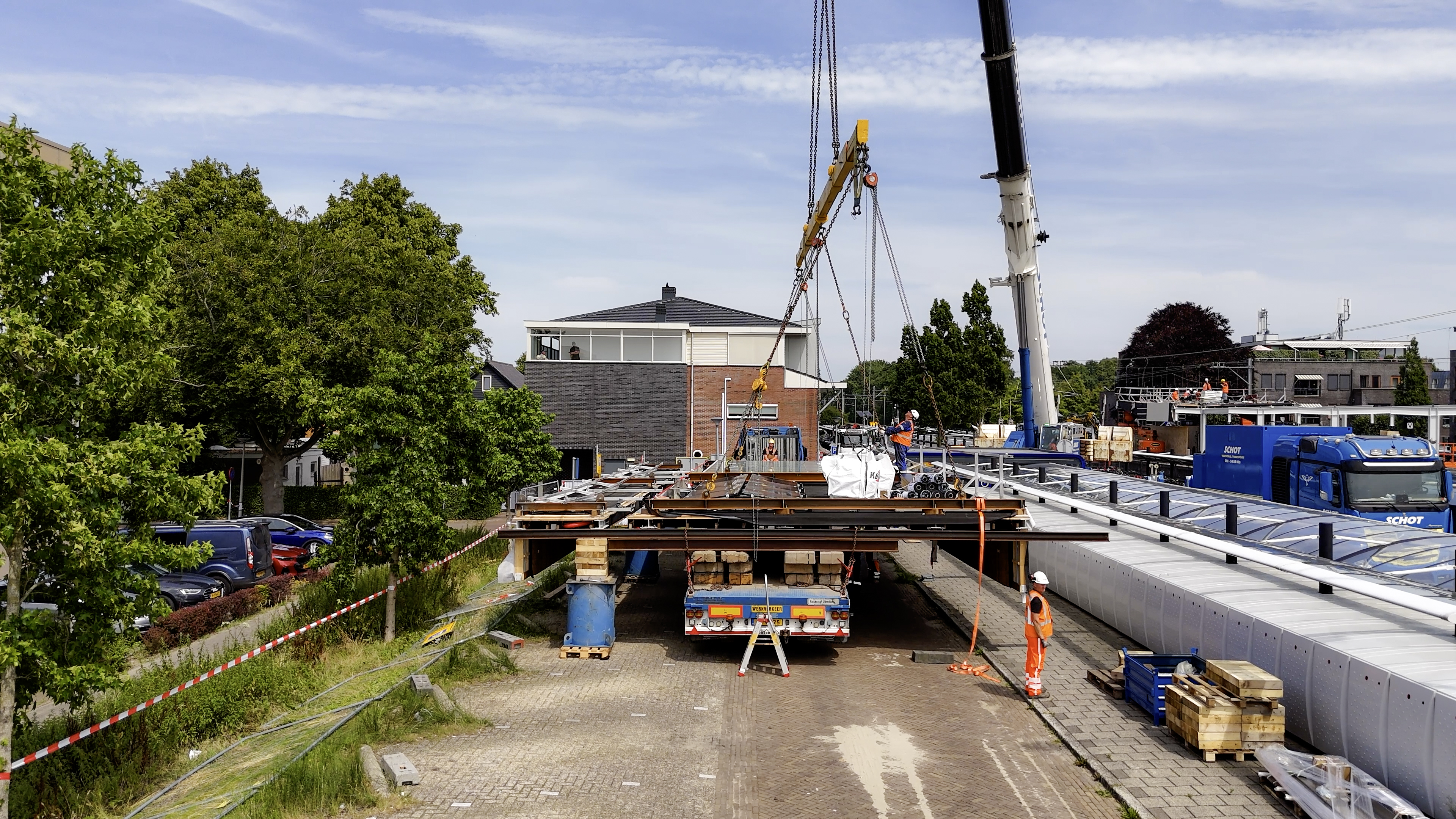 Met een gigantische kraan takelt aannemer K_Dekker de nieuwe perronkap op het perron