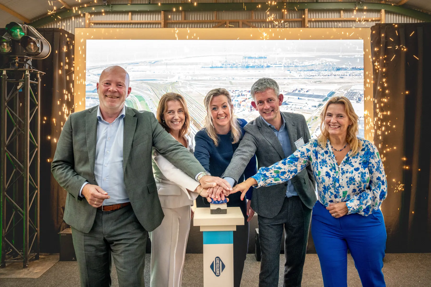 Gezamenlijk een druk op de knop en het sein springt op groen. De bouw gaat van start.  Vlrn: Robert Simons, wethouder gemeente Rotterdam, Mirjam van Velthuizen, CFO ProRail, Berte Simons, COO Havenbedrijf, Niek Lentink, CEO Swietelsky en Jeanette Baljeu, Europarlementariër