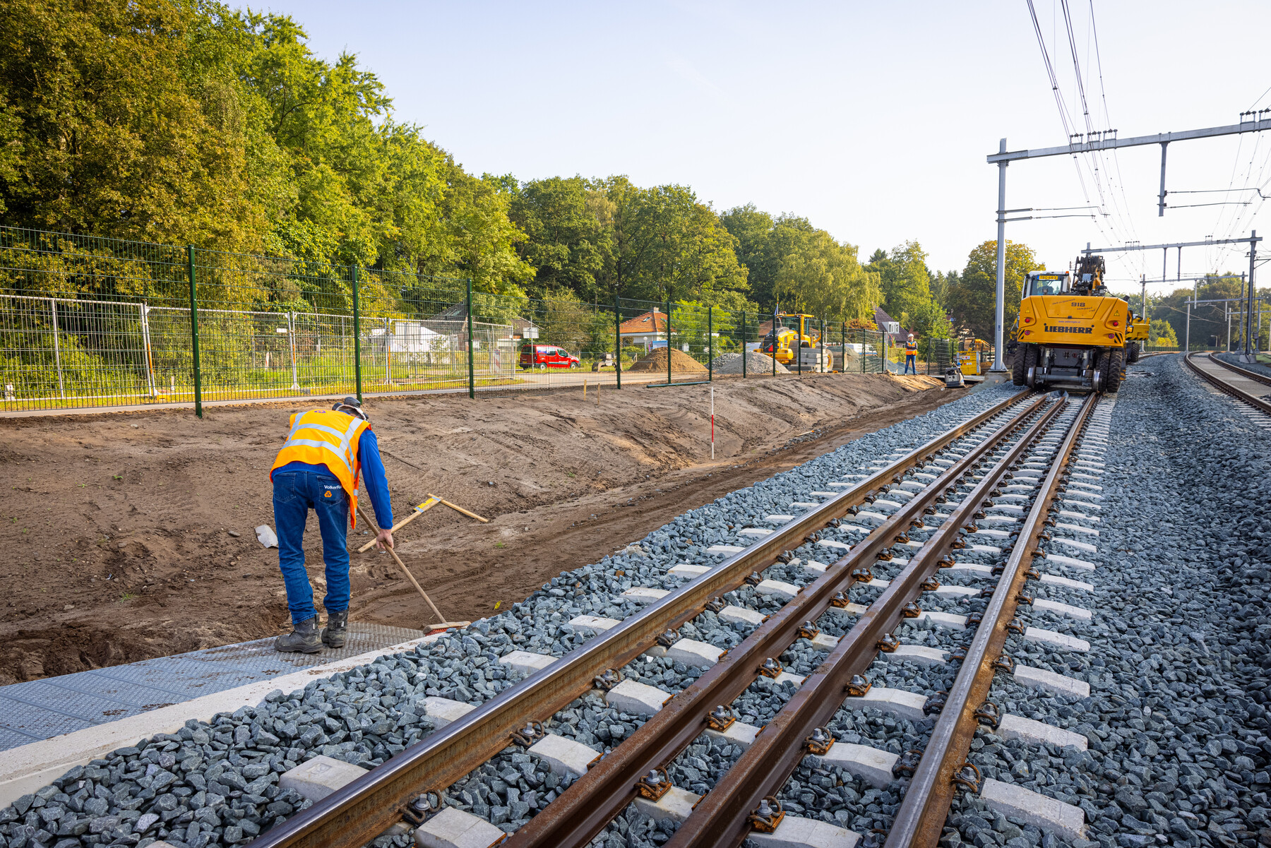 Laatste werkzaamheden naast het spoor, afwerken van de paden
