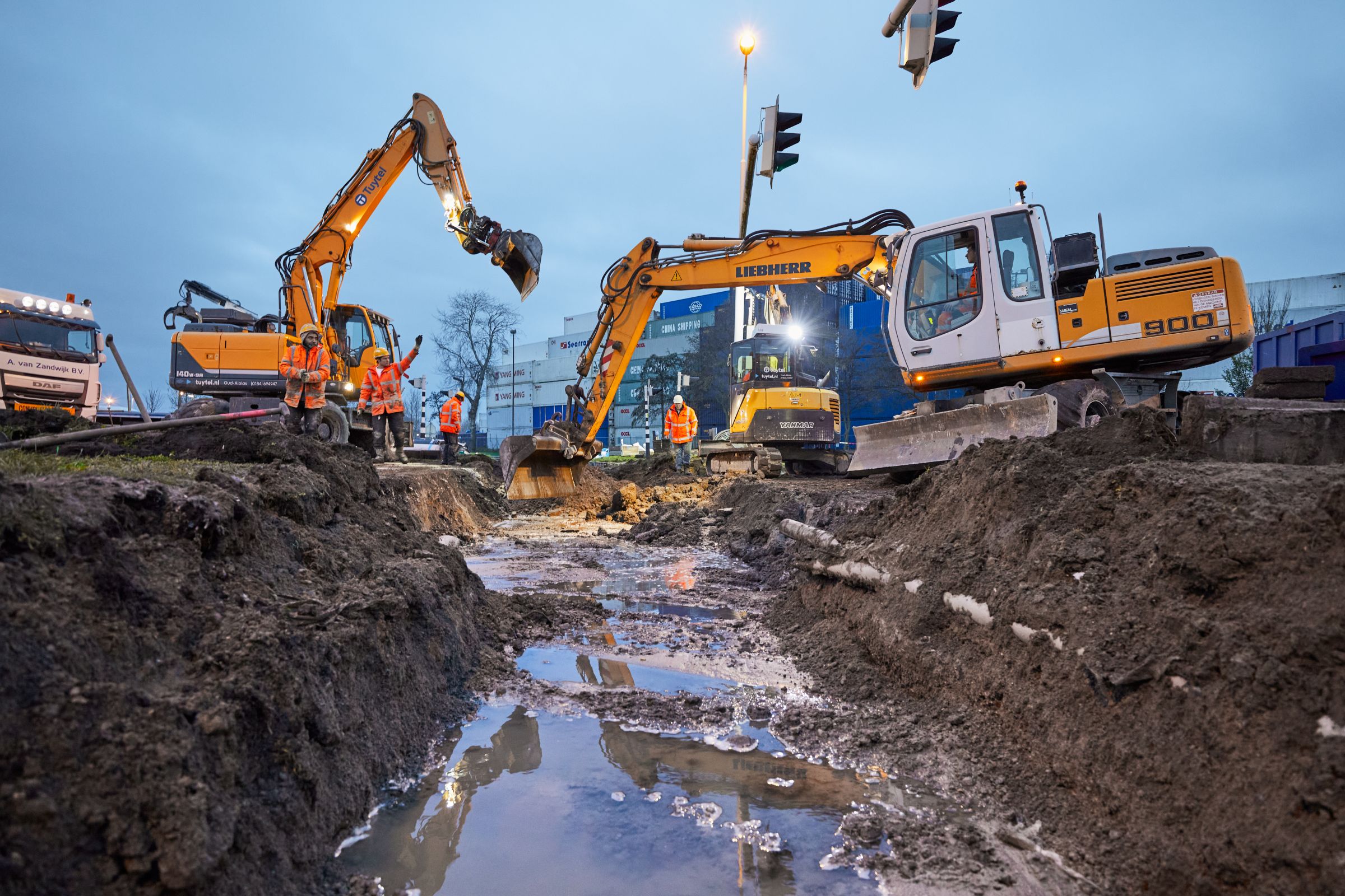 De graafmachines maken de ondergrond klaar voor de nieuwe overweg