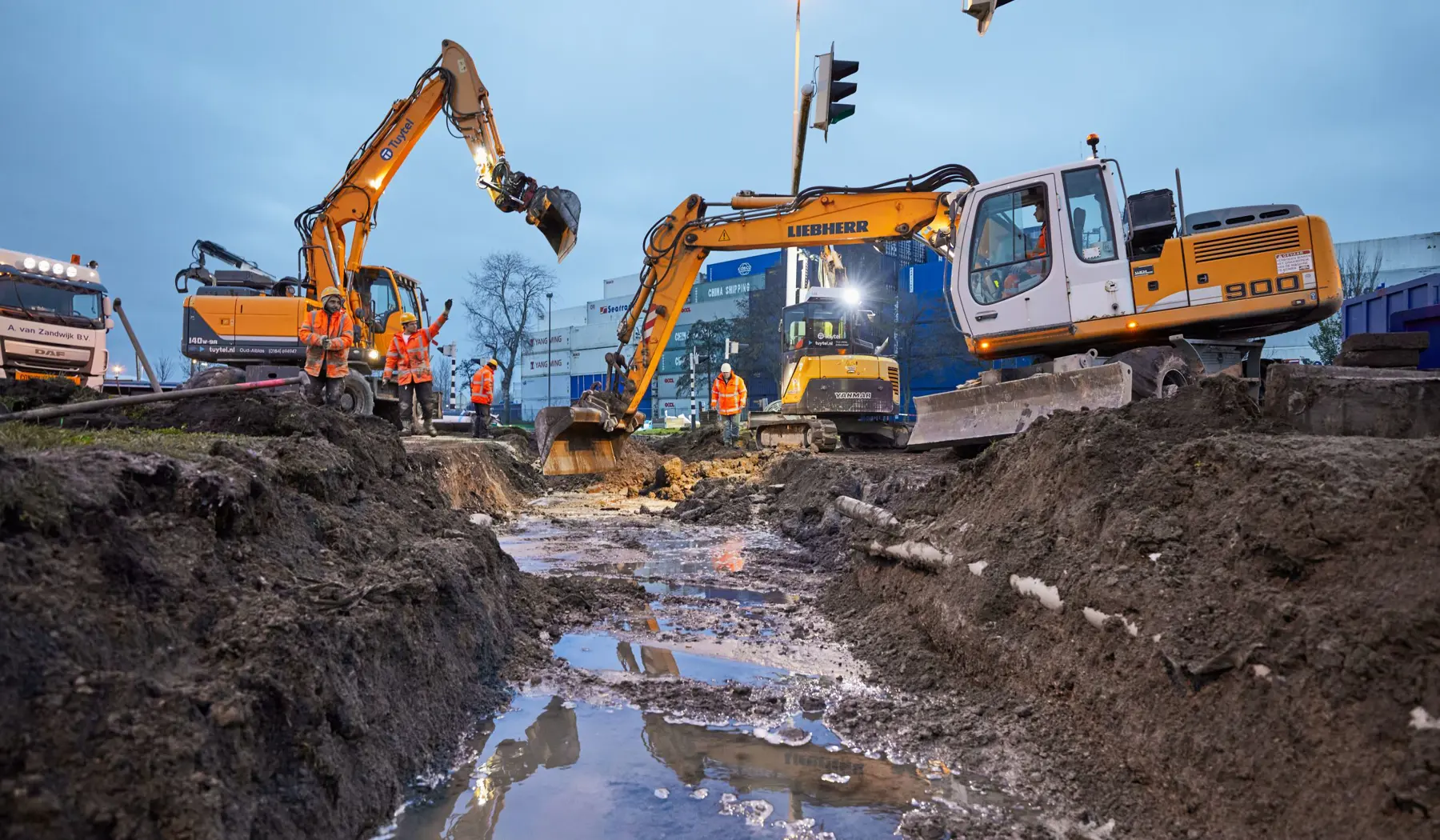 De graafmachines maken de ondergrond klaar voor de nieuwe overweg