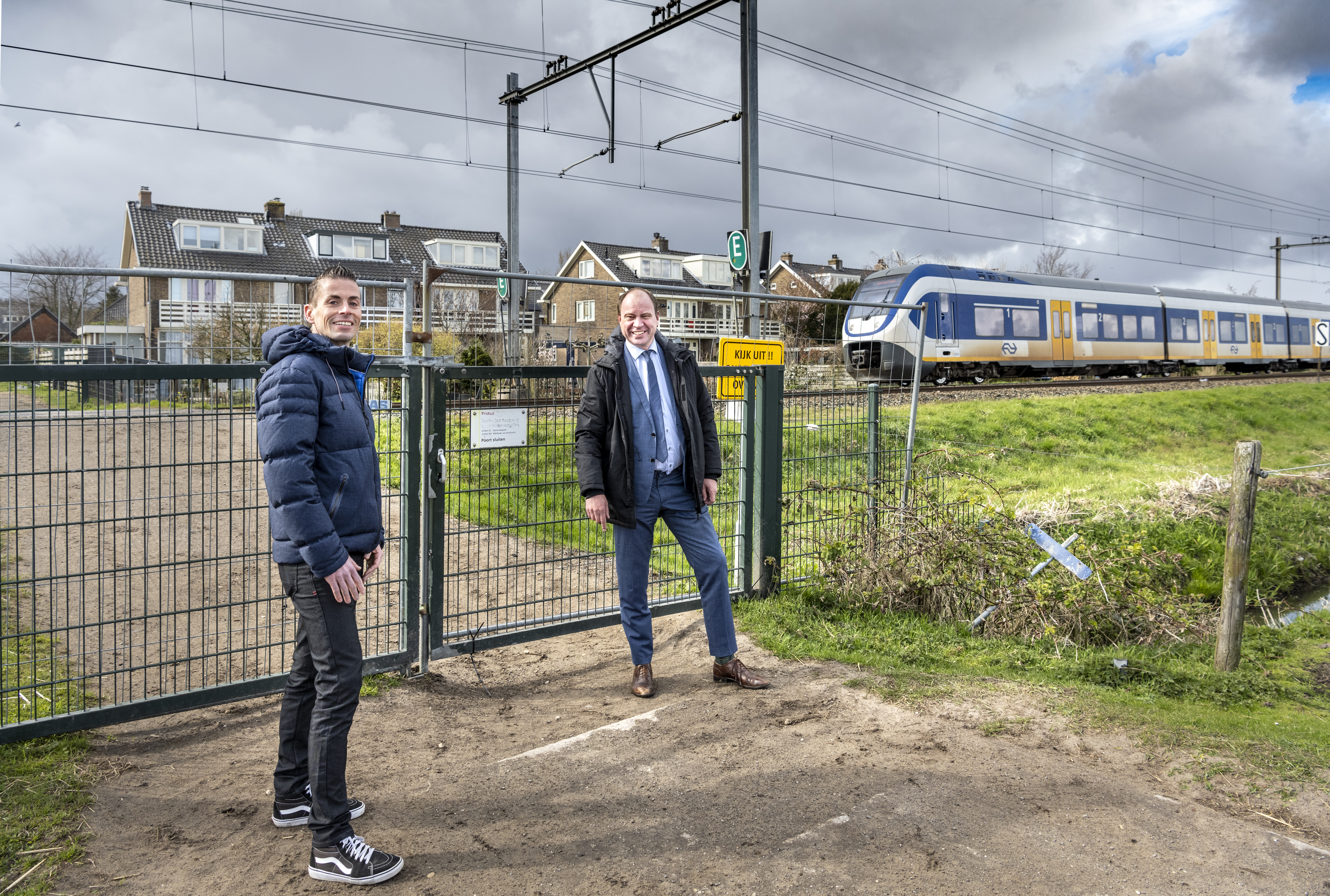 Harro Homan (regiodirecteur bij ProRail) en Bram Diepstraten (wethouder bij de gemeente Velsen) bij de overweg in Santpoort