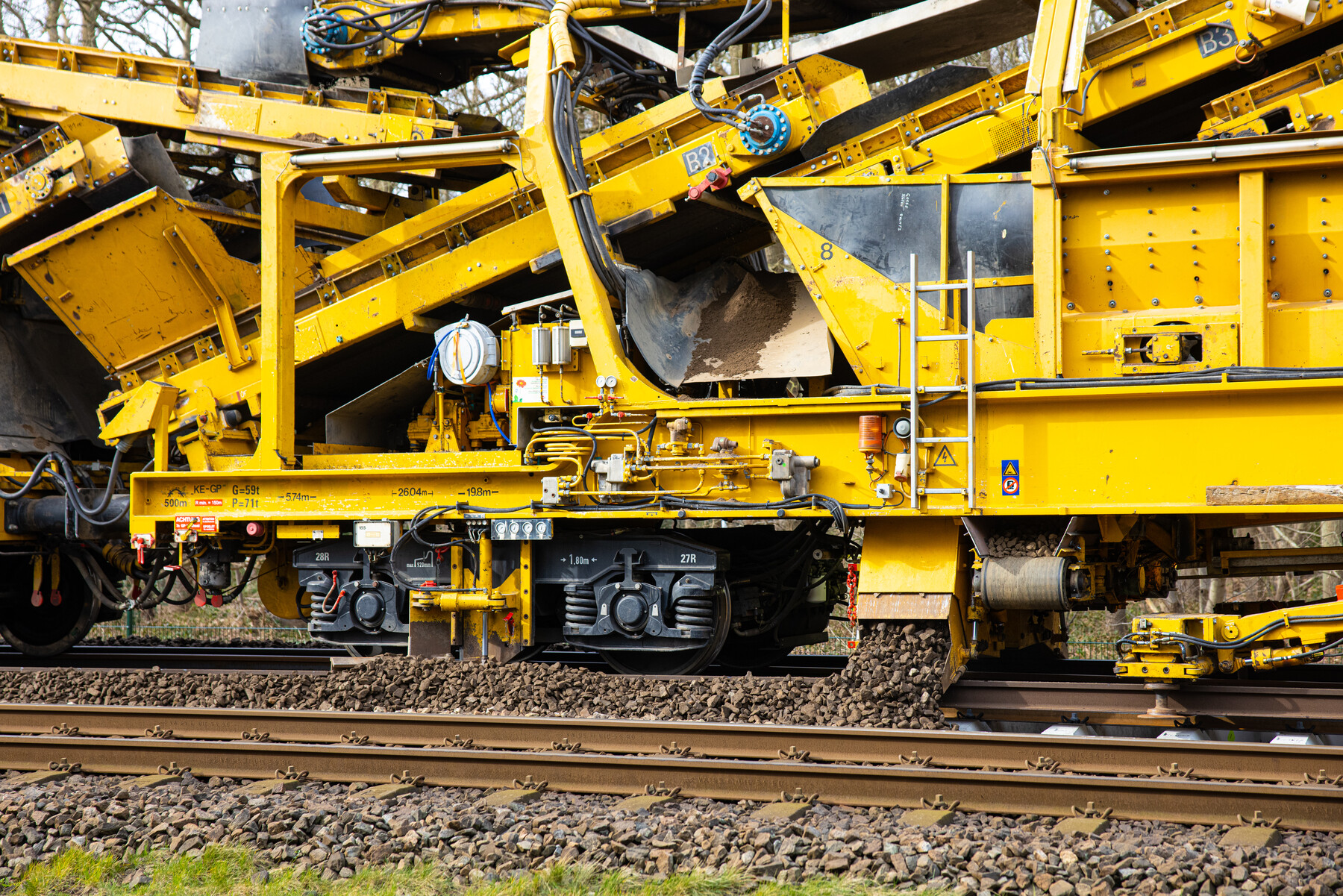 Schoongemaakte ballast wordt weer in het spoor gelegd