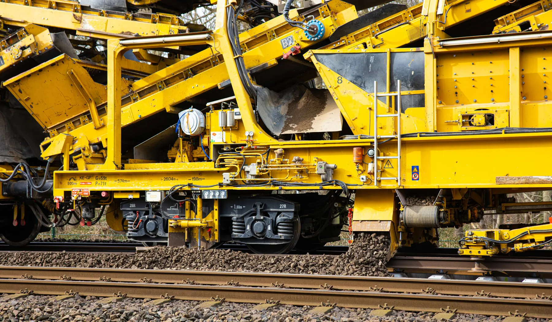 Schoongemaakte ballast wordt weer in het spoor gelegd