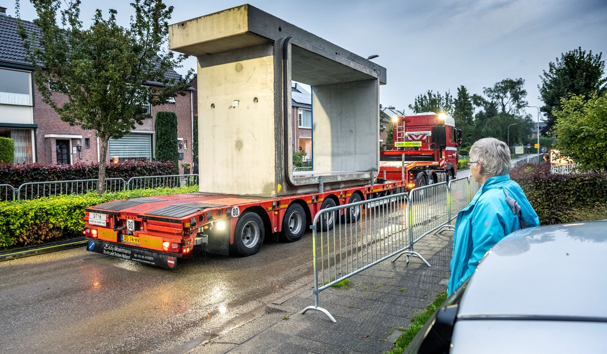 Vrachtwagens rijden de betonelementen één voor één Tricht binnen naar de hijskraan