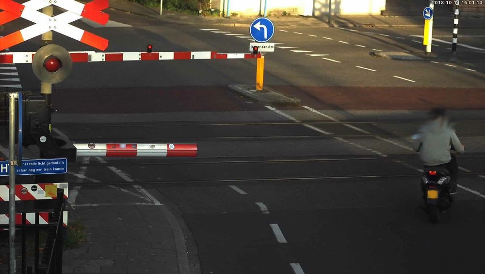 Een brommer slalomt langs gesloten bomen