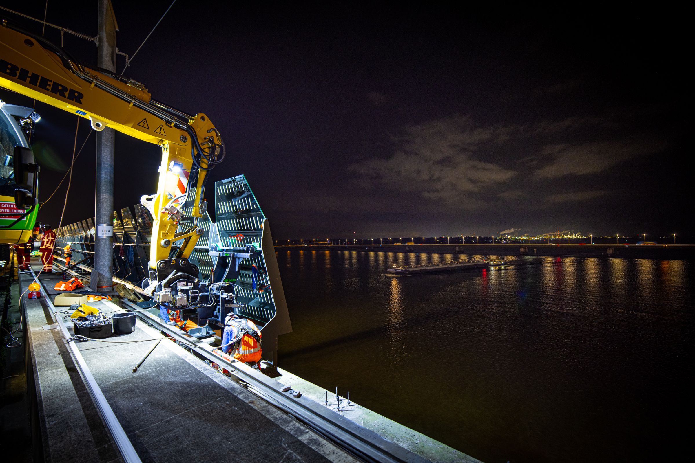 Er wordt dag en nacht doorgewerkt aan het plaatsen van windschermen op de Moerdijkbrug