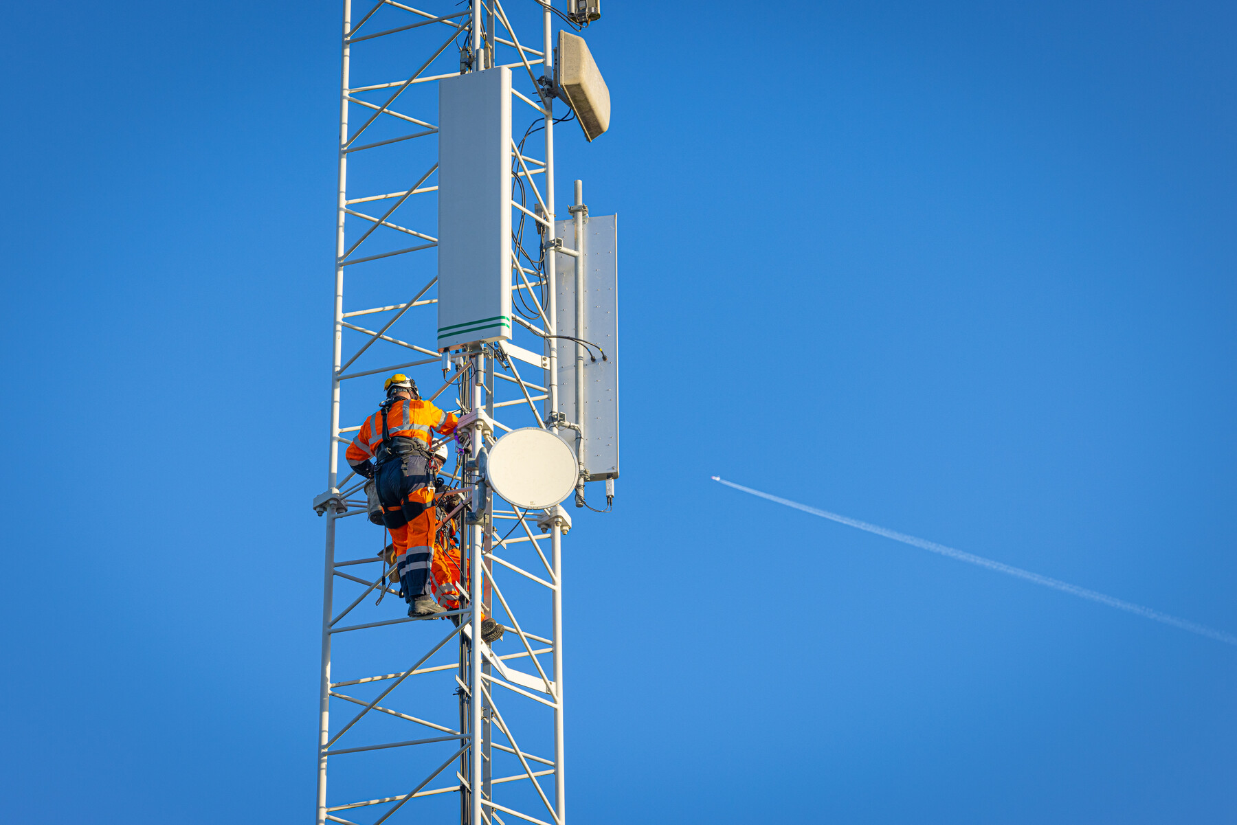 Een monteur klimt in een mast
