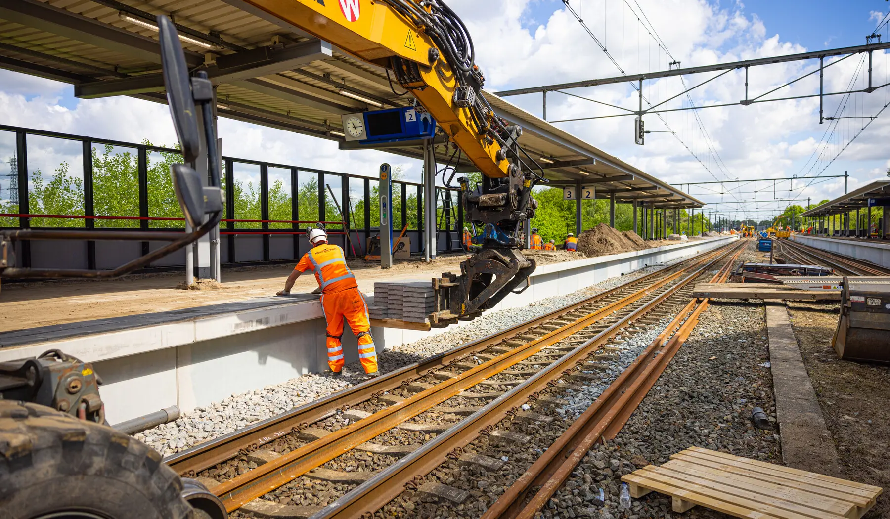 De perrontegels worden aangevoerd met een krol (kraan op lorries)