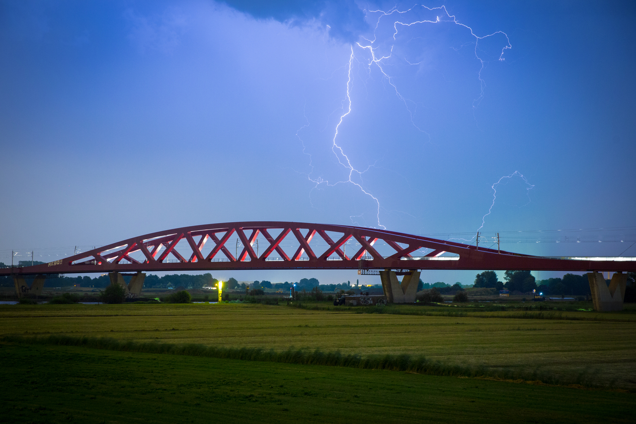 Bliksem boven een spoorbrug
